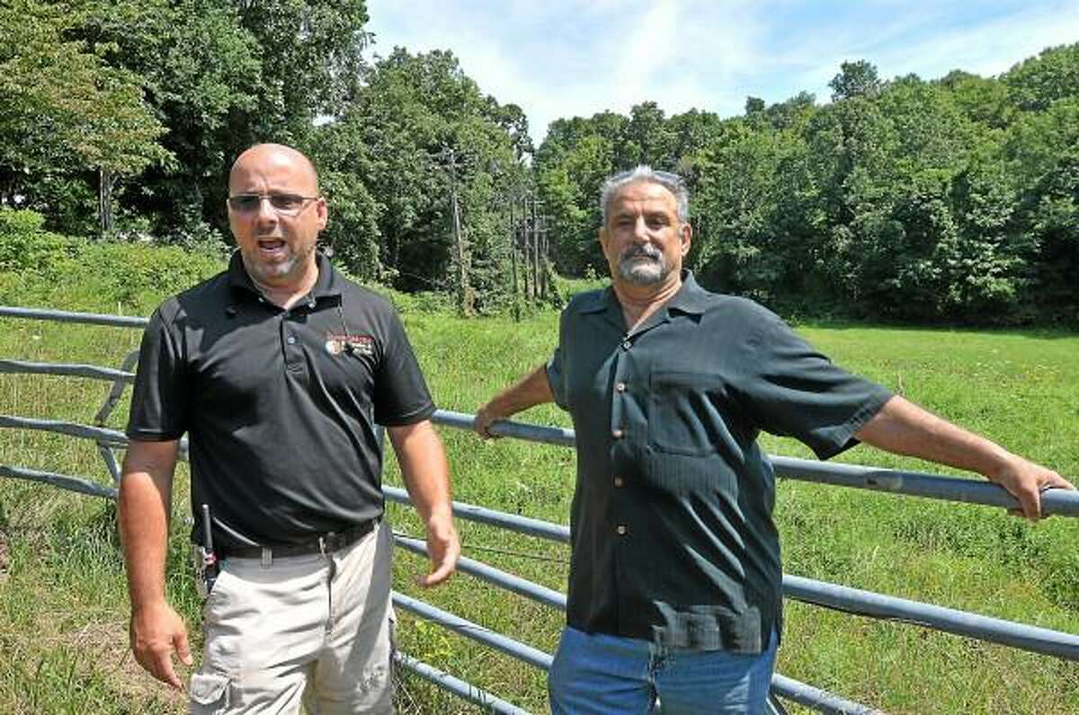 Sean Hayes, left, owner of Powder Ridge Mountain Park & Resort in Middlefield and investor, John Gramegna are frustrated with the lack of cooperation from CL&P and AT&T for the past nine months as contractors continue to work with generators. Hayes is currently waiting for 500 yards of power lines to be restored by the utility companies. Hayes has spent over $100,000 repairing and replacing utility poles on the property and completed the upgrade of 13 transformers because CL&P did not want to provide the same power voltage that was provided to the previous owners. Catherine Avalone - The Middletown Press