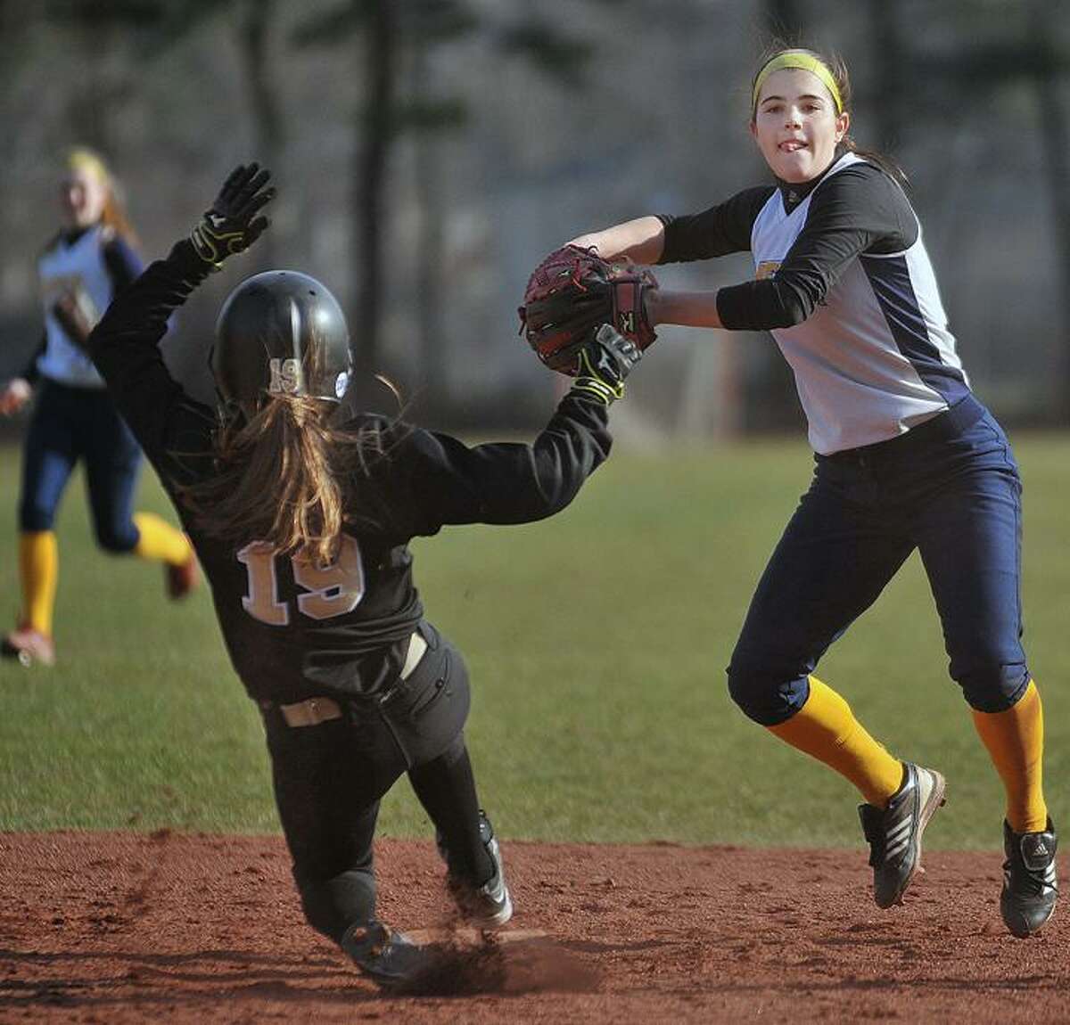 Catherine Avalone/The Middletown Press Mercy shortstop Astin Donovan makes the throw to first to complete a double play against Jonathan Law-Milford Thursday afternoon. Mercy defeated the Lawmen 3-2 at home.