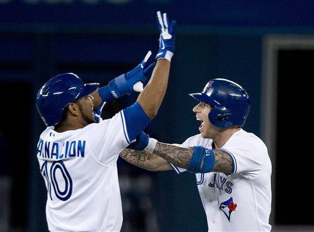 Toronto Blue Jays' Brett Lawrie, right, celebrates with Edwin Encarnacion after Lawrie hit a single to drive in the winning run against the Boston Red Sox during the 10th inning of a baseball game in Toronto on Wednesday, Aug. 14, 2013. Toronto won 4-3. (AP Photo/The Canadian Press, Nathan Denette)