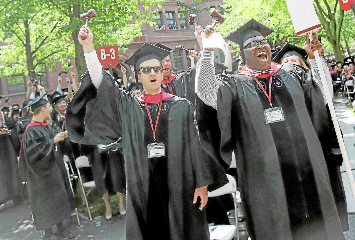 Adam Derry, left, and Jordan Christopher Wall, right, lead the cheers from students graduating from Harvard University’s School of Law during commencement ceremonies in Cambridge, Mass., Thursday, May 30, 2013.