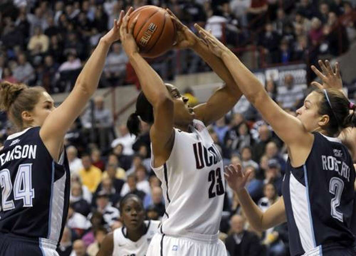 Connecticut's Maya Moore, center, takes a shot as Vilanova's Megan Pearson, left, and Rachel Roberts, right, defend during the first half of an NCAA college basketball game in Storrs, Conn., Wednesday, Jan. 5, 2011. (AP Photo/Bob Child)