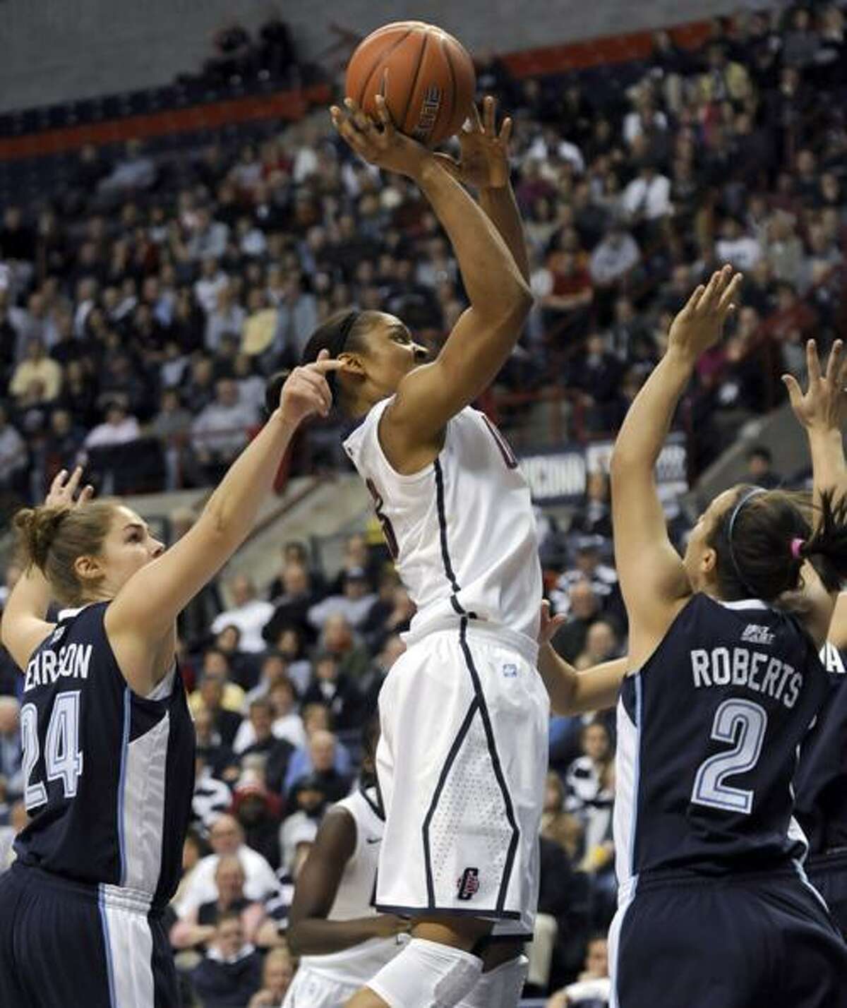 Connecticut's Maya Moore takes a one-hander goes up for a shot as Villanova's Megan Pearson, left, and Rachel Roberts, right, defend during the first half of an NCAA college basketball game in Storrs, Conn., Wednesday, Jan. 5, 2011. (AP Photo/Bob Child)