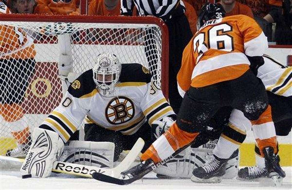 Boston Bruins goalie Tim Thomas, left, blocks a shot by Philadelphia Flyers' Darroll Powe during the first period in Game 1 of the Eastern Conference semifinal NHL Stanley Cup playoffs series, Saturday, April 30, 2011, in Philadelphia. (AP Photo/Matt Slocum)