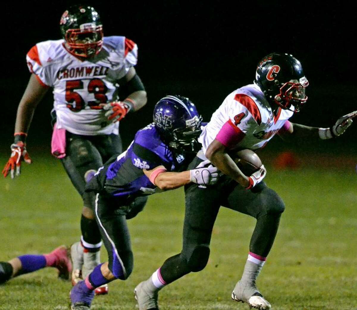 Cromwell running back Derrick Villard runs for a long gain after breaking a tackle from North Branford linebacker Gary Falanga. Photo by Sean Meenaghan/New Haven Register.