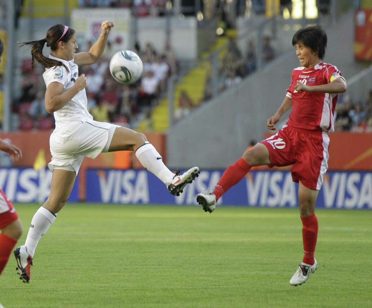 A US and North Korea player battle for the ball during the Group C match between the United States and North Korea at the Women's Soccer World Cup in Dresden, Germany, Tuesday, June 28, 2011. (AP Photo/Marcio Jose Sanchez)
