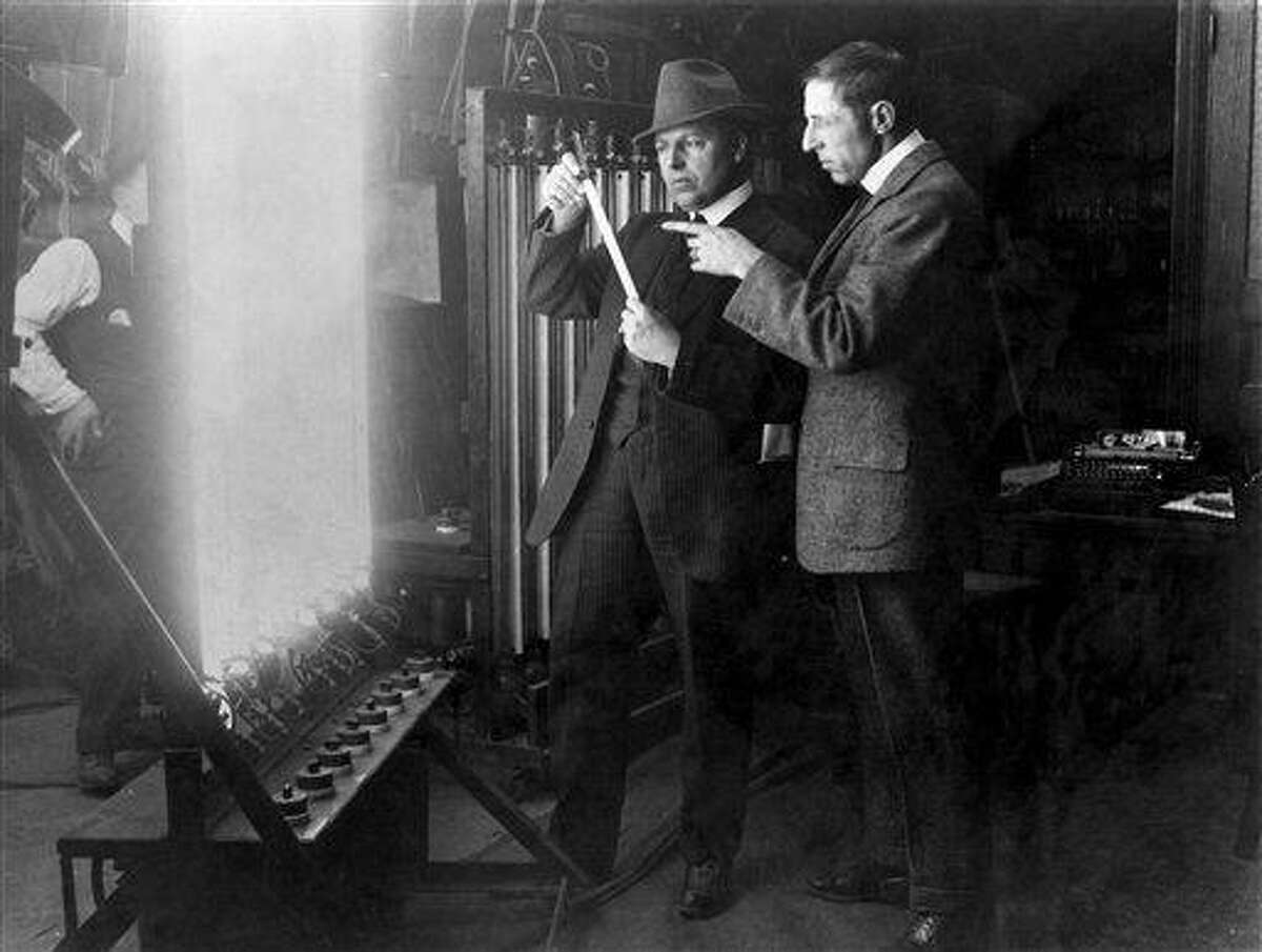 In this 1913 publicity image released by TCM, G.W "Billy" Bitzer, center, and D.W Griffith discuss early lighting techniques in a scene from seven-part documentary series "Moguls & Movie Stars: A History of Hollywood" beginning Monday, Nov. 1, 2010 on the Turner Classic Movie channel. (AP Photo/TCM) ** FOR ONE-TIME EDITORIAL USE ONLY WITH JAKE COYLE'S STORY: TV-MOGULS AND MOVIE STARS. NO SALES. **