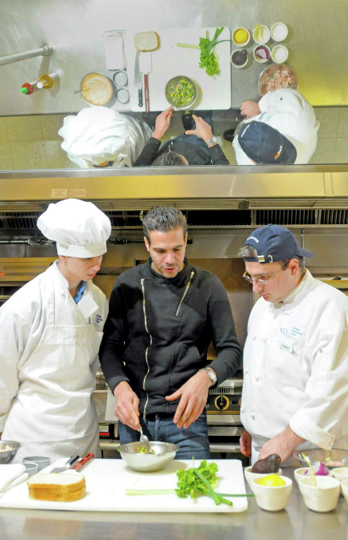 Angelo Sosa, a "Top Chef" contestant from season 7, center, with students Nicholas Shafransky of West Haven, left, and Joshua Semeraro of Waterbury at Gateway Community College in New Haven.(Peter Hvizdak/Journal Register News Service)