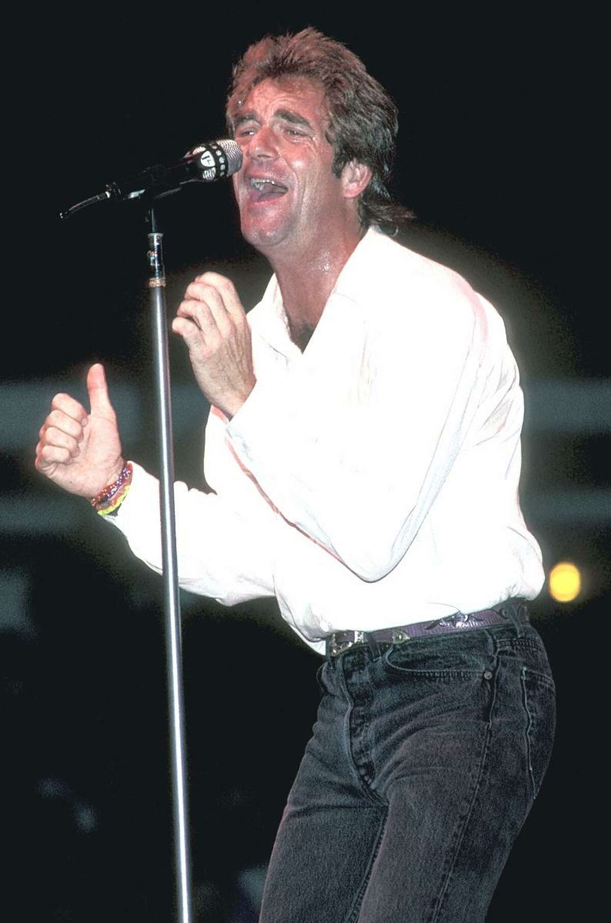 Singer Huey Lewis is shown performing on stage during a Huey Lewis & the News concert appearance.