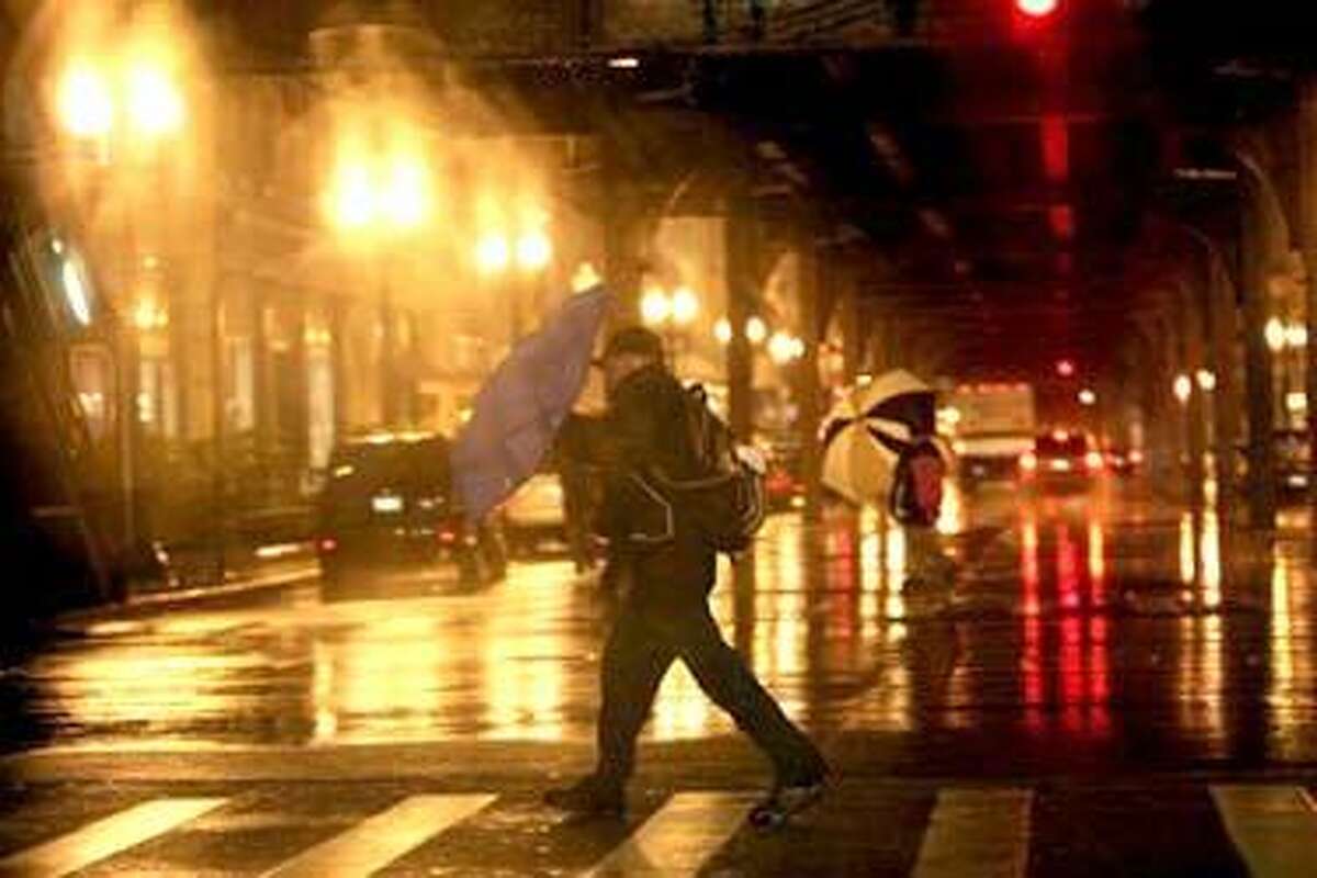 Pedestrians fight high winds and rain along East Madison Street and southbound Wabash Avenue in Chicago's Loop on Tuesday, Oct. 26, 2010. Strong wind and torrential rain buffeted the Midwest Tuesday as forecasters predicted the giant storm could be the most powerful to hit Illinois in over seven decades. (AP Photo/Chicago Tribune, Nancy Stone) THE NEW YORK TIMES OUT, CHICAGO LOCALS OUT, ROCKFORD REGISTER STAR OUT, MAGS OUT, NO SALES, TV OUT, ONLINE OUT