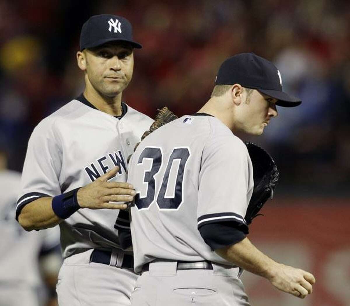 New York Yankees shortstop Derek Jeter, left, tries to calm relief pitcher David Robertson after Robertson gave up a two-run home run to Texas Rangers' Nelson Cruz in the fifth inning of Game 6 of baseball's American League Championship Series Friday in Arlington, Texas. (AP Photo/Tony Gutierrez)