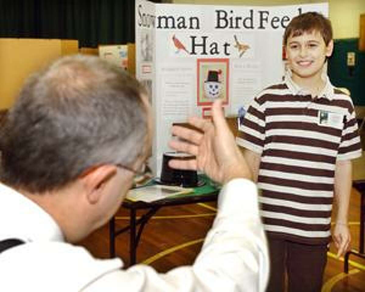 The Middletown Press) Tyler J. Beaulieu, a fourth-grade student at Center School, demonstrates to judges how his invention, the Handsfree Umbrella, works.