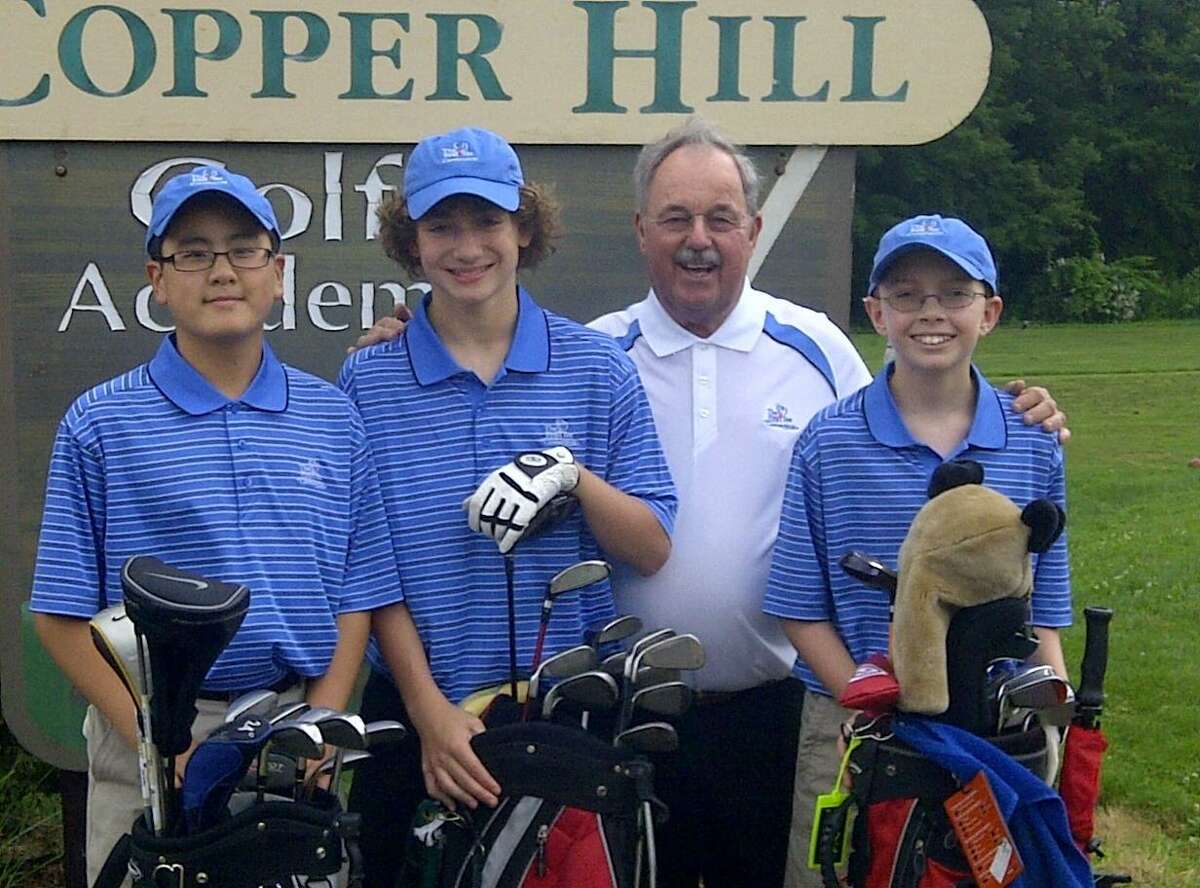 DAN PODHEISER - MIDDLETOWN PRESS - Jason Liu, left, AJ Ouimet, second left, and Chase Skrubis, right, will play in Pro-Am events at The Travelers Championship at TPC River Highlands in Cromwell on Tuesday and Wednesday thanks to The First Tee of Connecticut. Vic Svenberg, second right, is the founder of The First Tee's Suffield branch and mentor to the three boys.