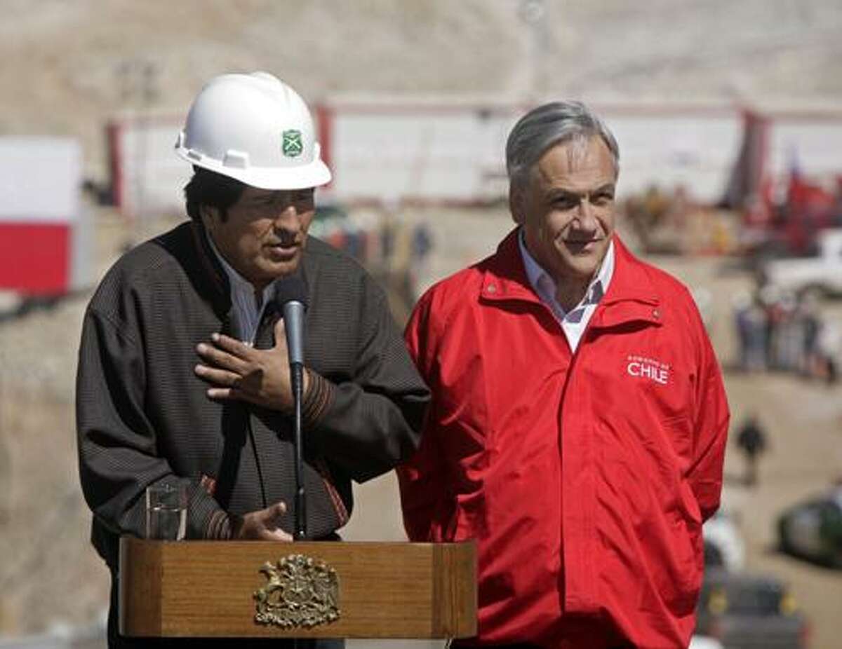 Bolivia's President Evo Morales, left, speaks during a joint news conference with his Chilean counterpart Sebastian Pinera next to the site where the 33 trapped miners are being rescued at the San Jose gold and copper mine near Copiapo, Chile, Wednesday, Oct. 13, 2010. (AP Photo/Jorge Saenz)
