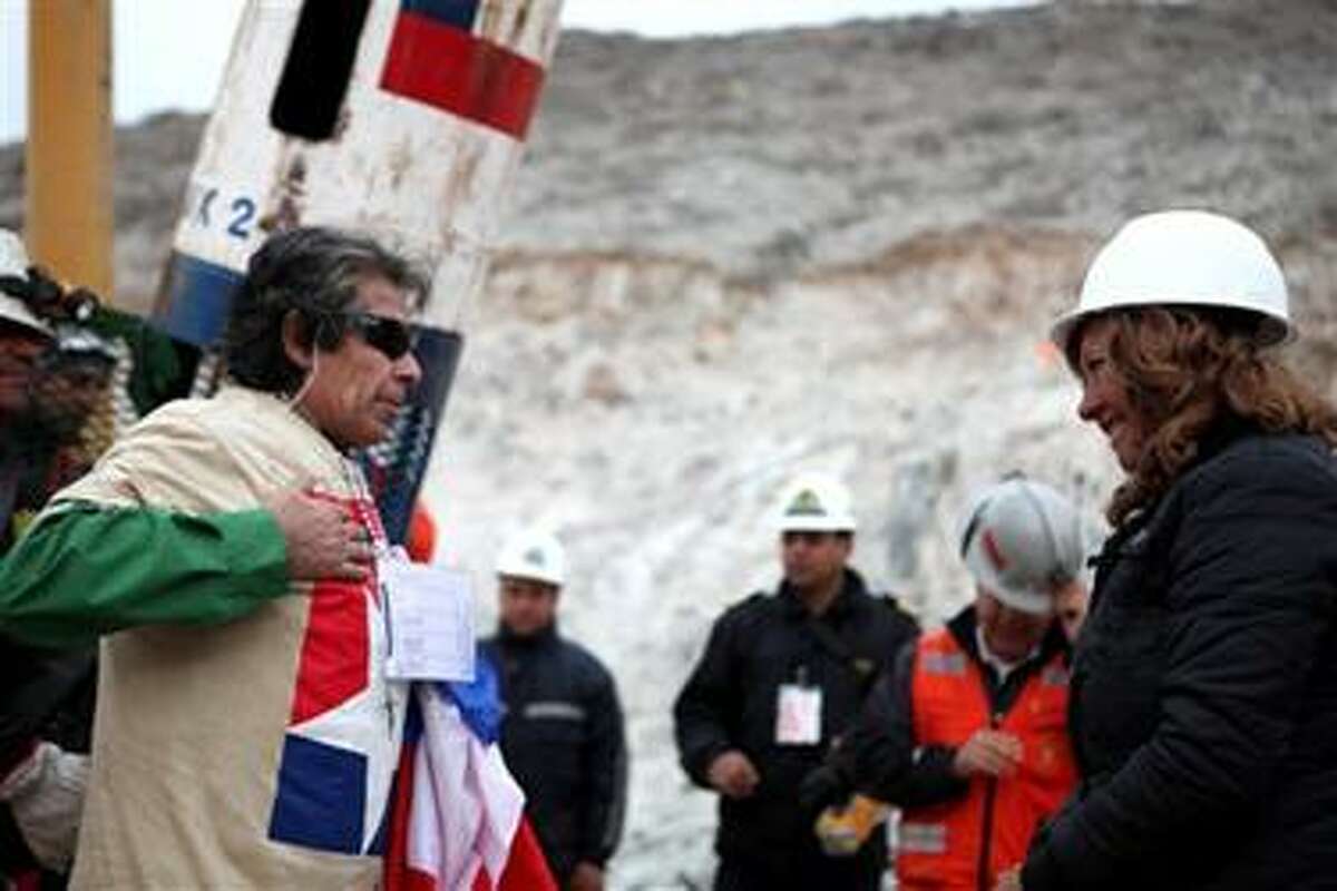 In this photo released by the Chilean government, miner Mario Gomez, left, gestures as he meets his wife for the first time after being rescued from the collapsed San Jose gold and copper mine where he had been trapped with 32 other miners for over two months near Copiapo, Chile, Wednesday, Oct. 13, 2010. (AP Photo/Hugo Infante, Chilean government)