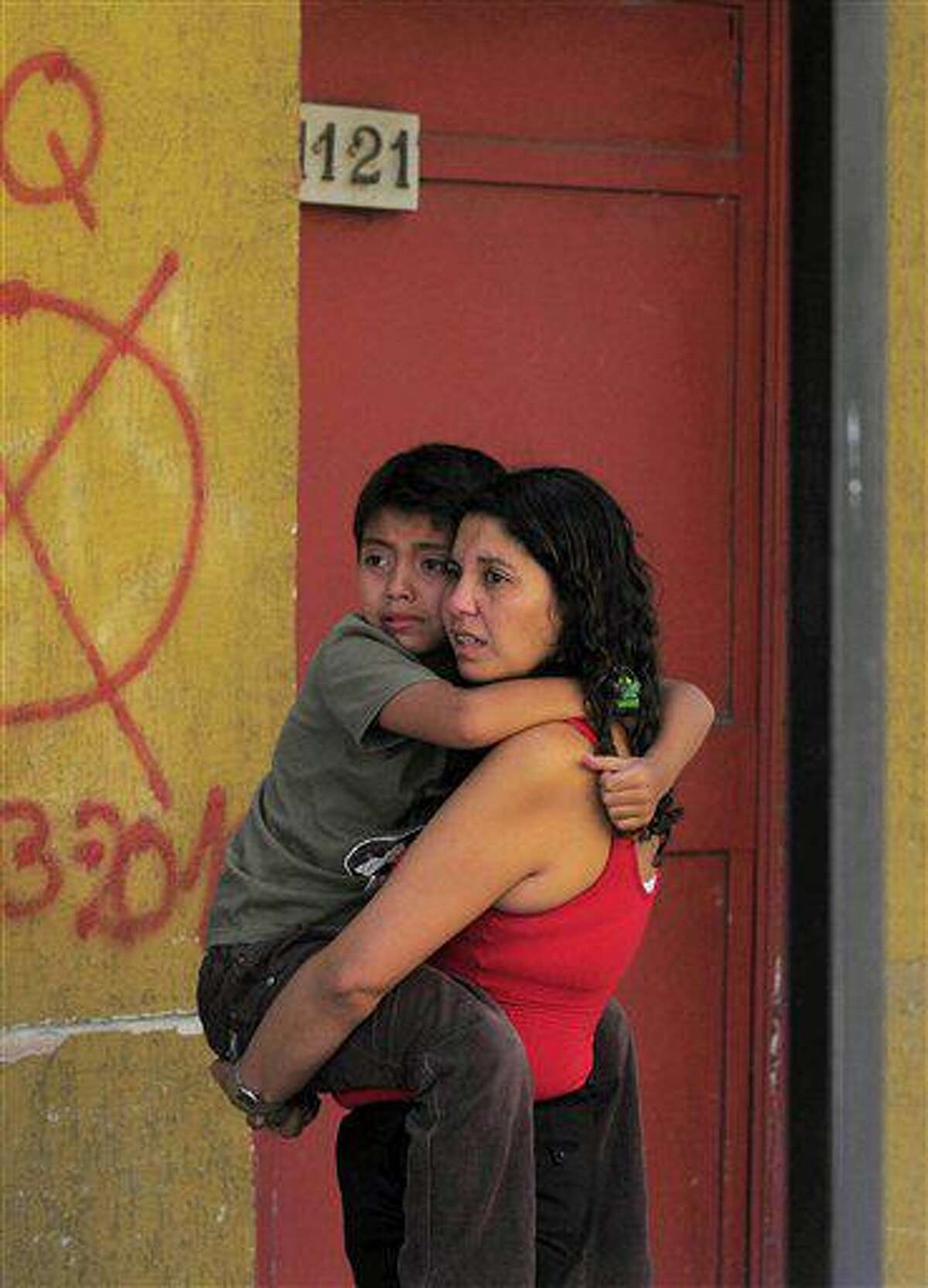A woman holds a child as they stand outside a building as a precaution after a magnitude-6.8 earthquake in Concepcion, Chile, Friday Feb. 11, 2011. The earthquake struck central Chile Friday, centered in almost exactly the same spot where last year's magnitude-8.8 quake spawned a tsunami and devastated coastal communities. Electricity and phone service were disrupted and thousands of people fled to higher ground following Friday's quake, but the government quickly announced that there was no risk of a tsunami, and there were no reports of damage or injuries. (AP Photo/Francisco Negroni)
