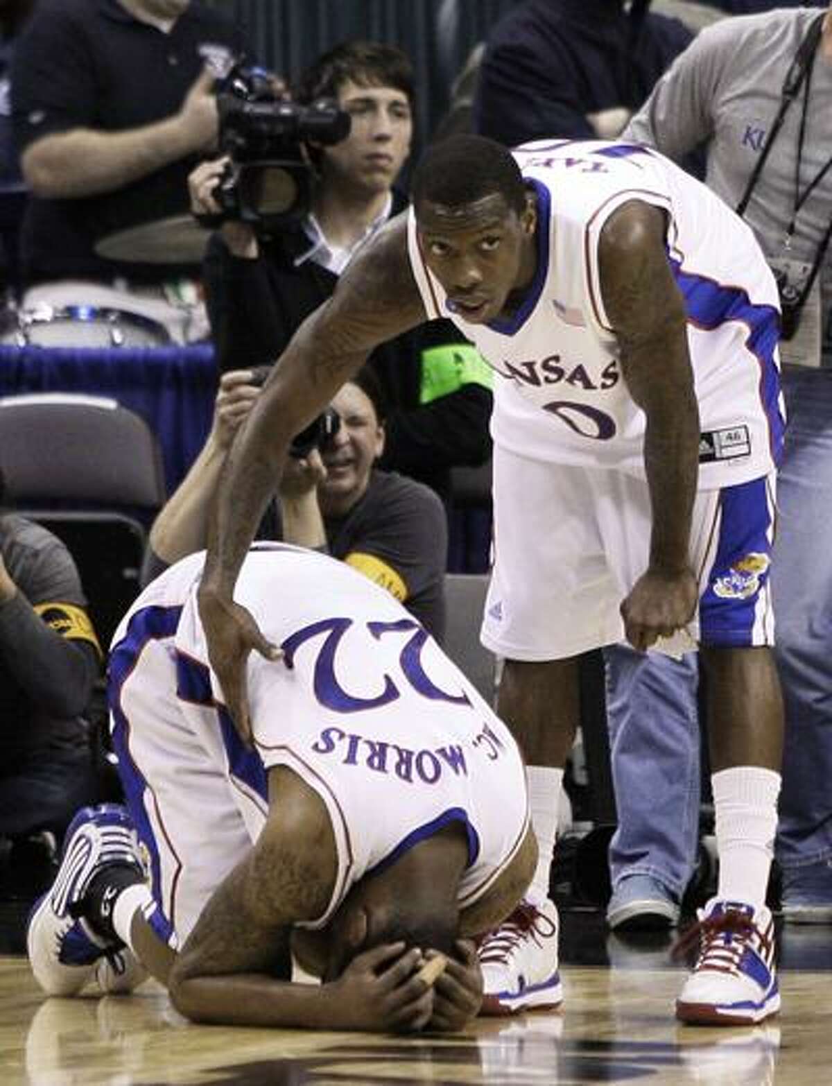 Kansas guard Tyshawn Taylor, right, consoles Kansas forward Marcus Morris (22) after their 69-67 loss to Northern Iowa in an NCAA second-round college basketball game, Saturday. (Associated Press)