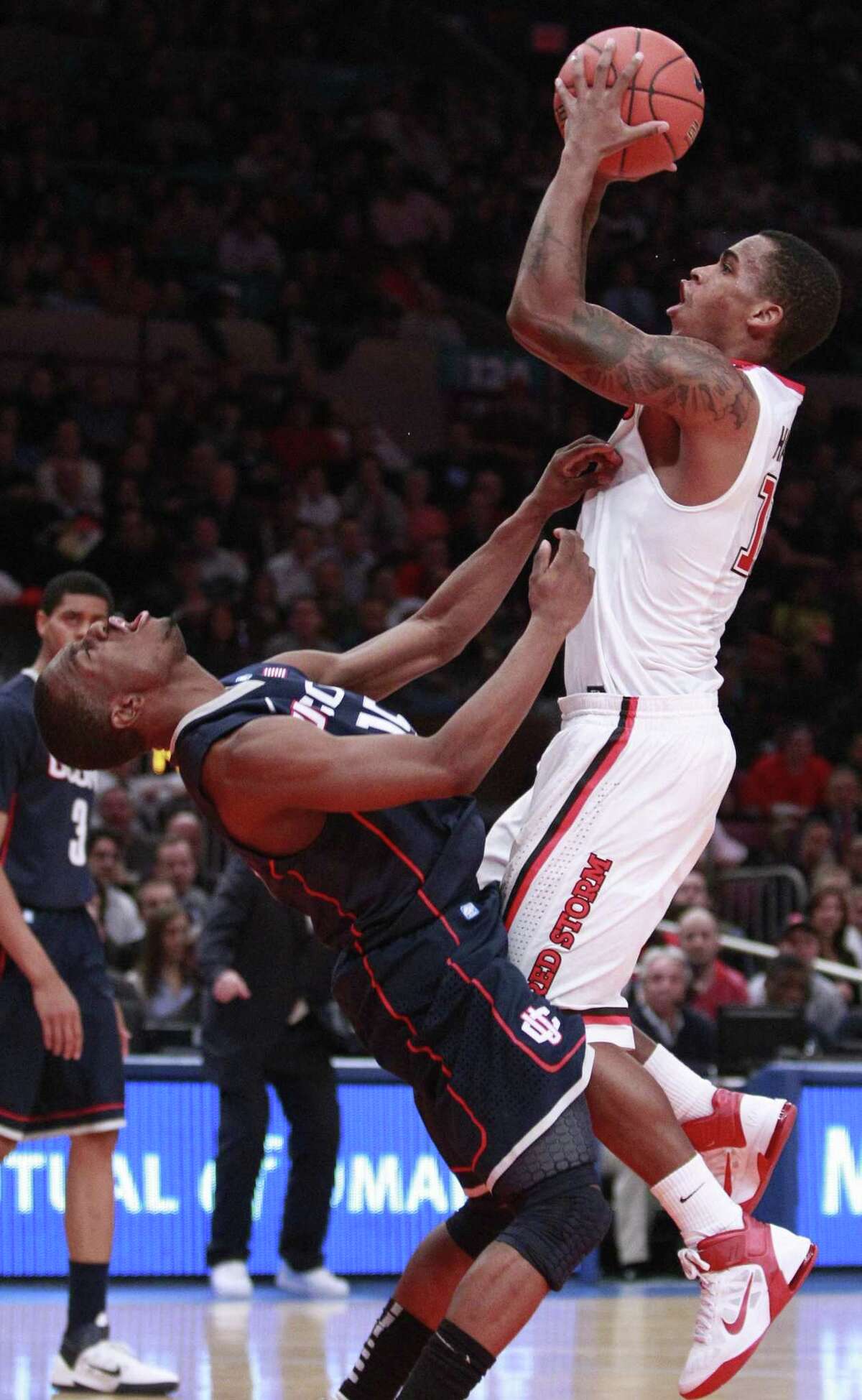 AP St. John's Dwight Hardy, right, scores as he is fouled by Connecticut's Kemba Walker in the second half of an NCAA college basketball game Thursday in New York. Hardy scored 33 points as St. John's won the game 89-72.
