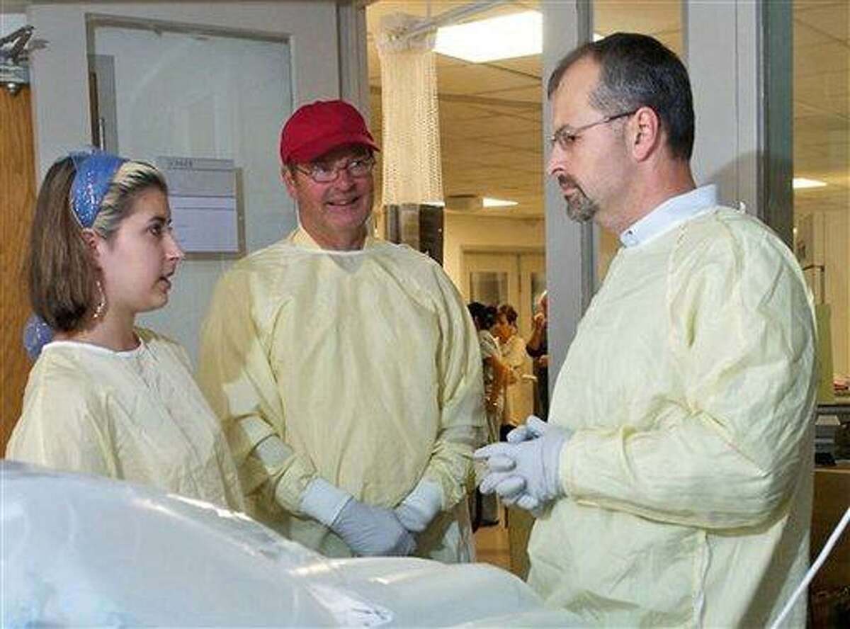In this undated photo provided by Brigham and Women's Hospital, Steve Nash, center, brother of Charla Nash, and Charla's daughter Briana, left, speak with surgeon Bohdan Pomahac, MD, right, in Charla's room at the hospital in Boston. Charla Nash underwent a full face transplant more than two years after she was mauled and blinded by the chimpanzee. (AP Photo/Brigham and Women's Hospital)