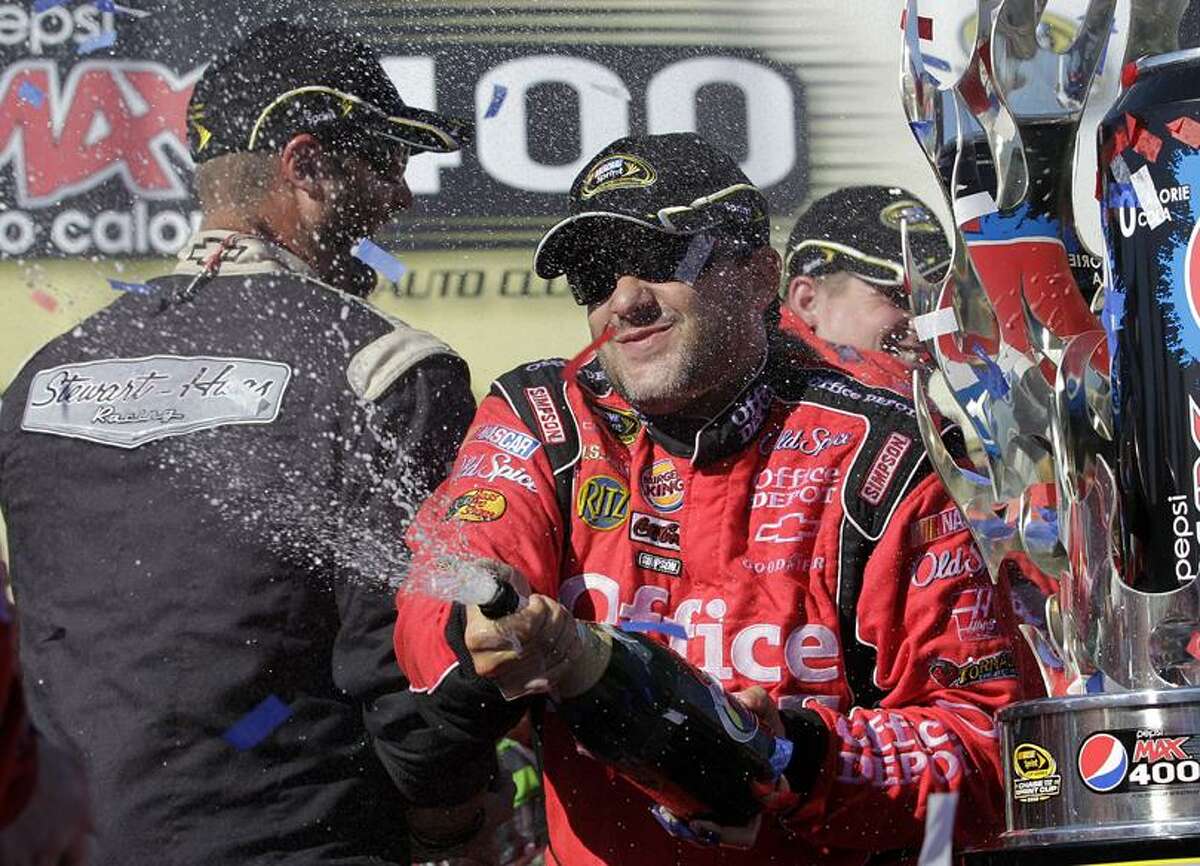 Tony Stewart celebrates after winning the NASCAR Sprint Cup Series auto race at Auto Club Speedway in Fontana, Calif., Sunday. (AP Photo/Jae C. Hong)