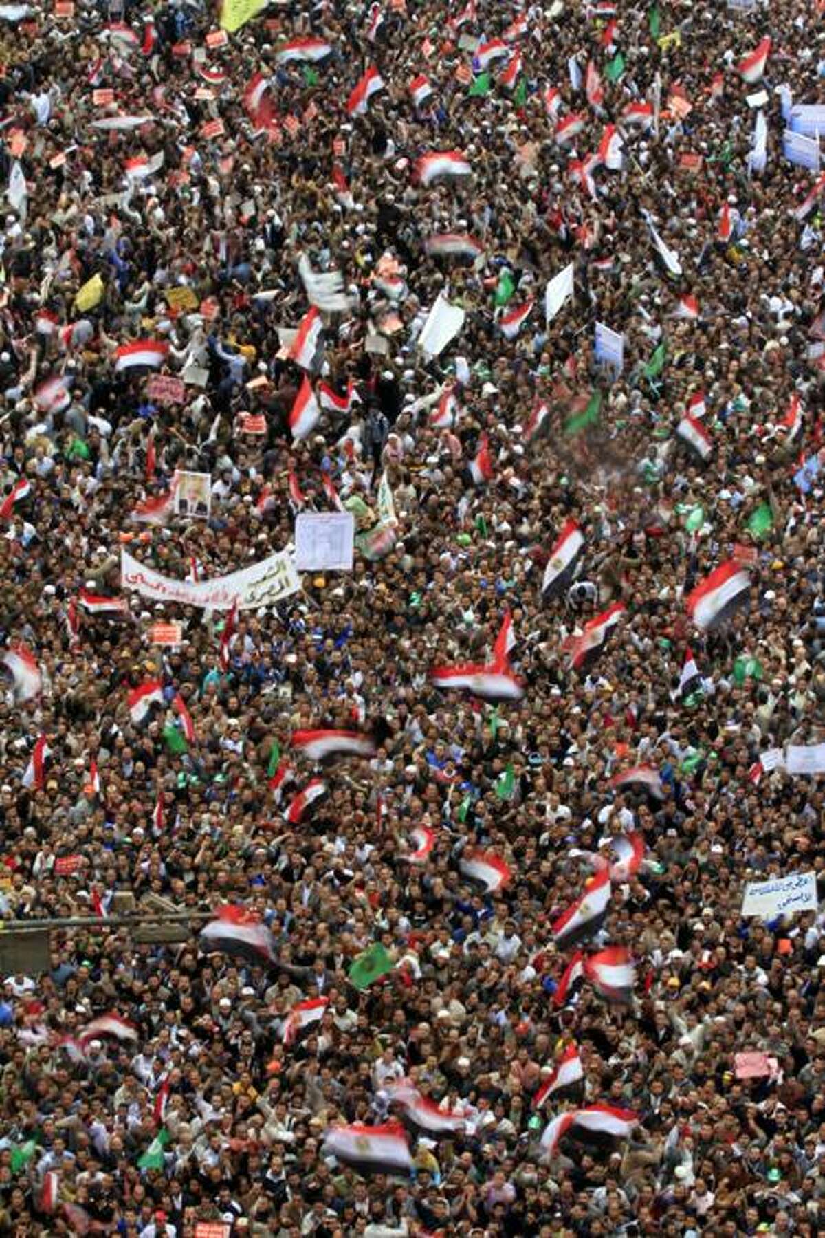 Protesters wave banners and Egyptian national flags in Tahrir Square, Cairo, Friday. Associated Press