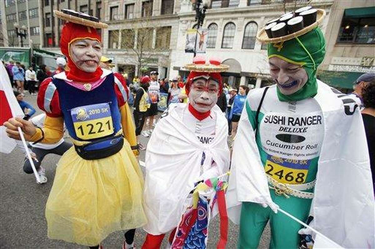 (AP) Dressed in a sushi theme, from left, Tetsutomo IIzuka, Yasuo Sakai and Mayumi Okunishi, all of Japan, wait for the start of a 5K race sponsored by the Boston Athletic Association in Boston, as a prelude to the 114th running of the Boston Marathon on Monday.