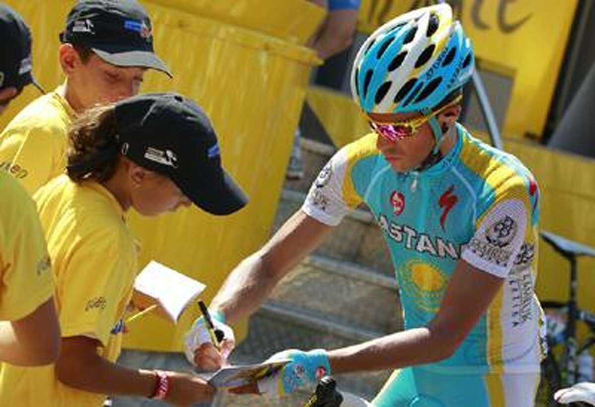 Alberto Contador of Spain signs autographs prior to the start of the 12th stage of the Tour de France cycling race over 210.5 kilometers (130.8 miles) with start in Bourg-de-Peage, and finish in Mende, France, Friday.
