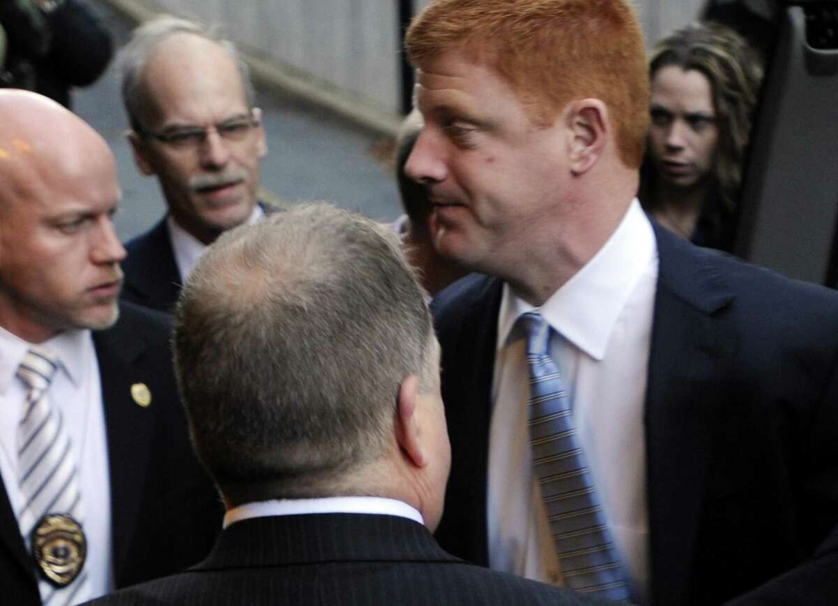 Penn State assistant football coach Mike McQueary, right, arrives at Dauphin County Court surrounded by heavy security Friday in Harrisburg, Pa. McQueary declined to speak to reporters Friday as he entered the courthouse in Harrisburg for the hearing for Gary Schultz and Tim Curley, who are set to appear for a preliminary hearing related to the Jerry Sandusky child sex abuse case. (AP Photo/Bradley C Bower)