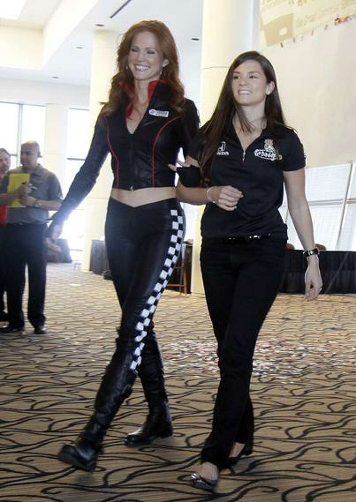 Driver Danica Patrick, right, is escorted during media day at Texas Motor Speedway in Fort Worth, Wednesday, Texas March 2, 2011. (AP Photo/LM Otero)