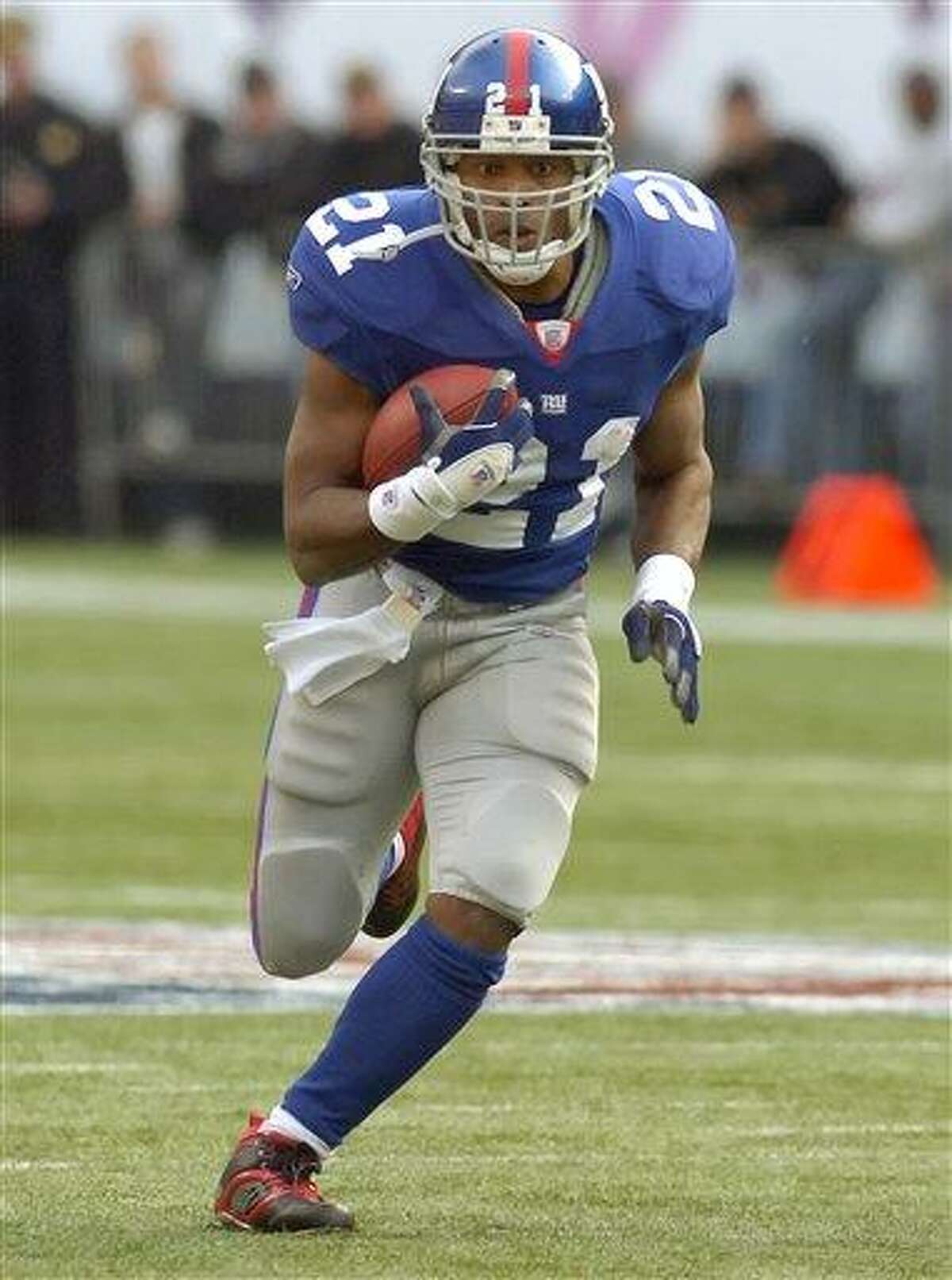 In this Nov. 5, 2006, photo, New York Giants running back Tiki Barber runs for a 13-yard gain during an NFL football against the Houston Texans in East Rutherford, N.J. Barber insists his attempt to return to the NFL after four years in retirement is not about money. The 36-year-old surprisingly retired in 2006 to pursue a broadcasting career. Then, just as surprisingly, he decided to give the NFL another shot. He asked the team to take him off the reserve-retirement list in March. The Giants said they will release him once the league allows it. Teams have not been allowed to make roster moves because of the labor fight. (AP Photo/Bill Kostroun)