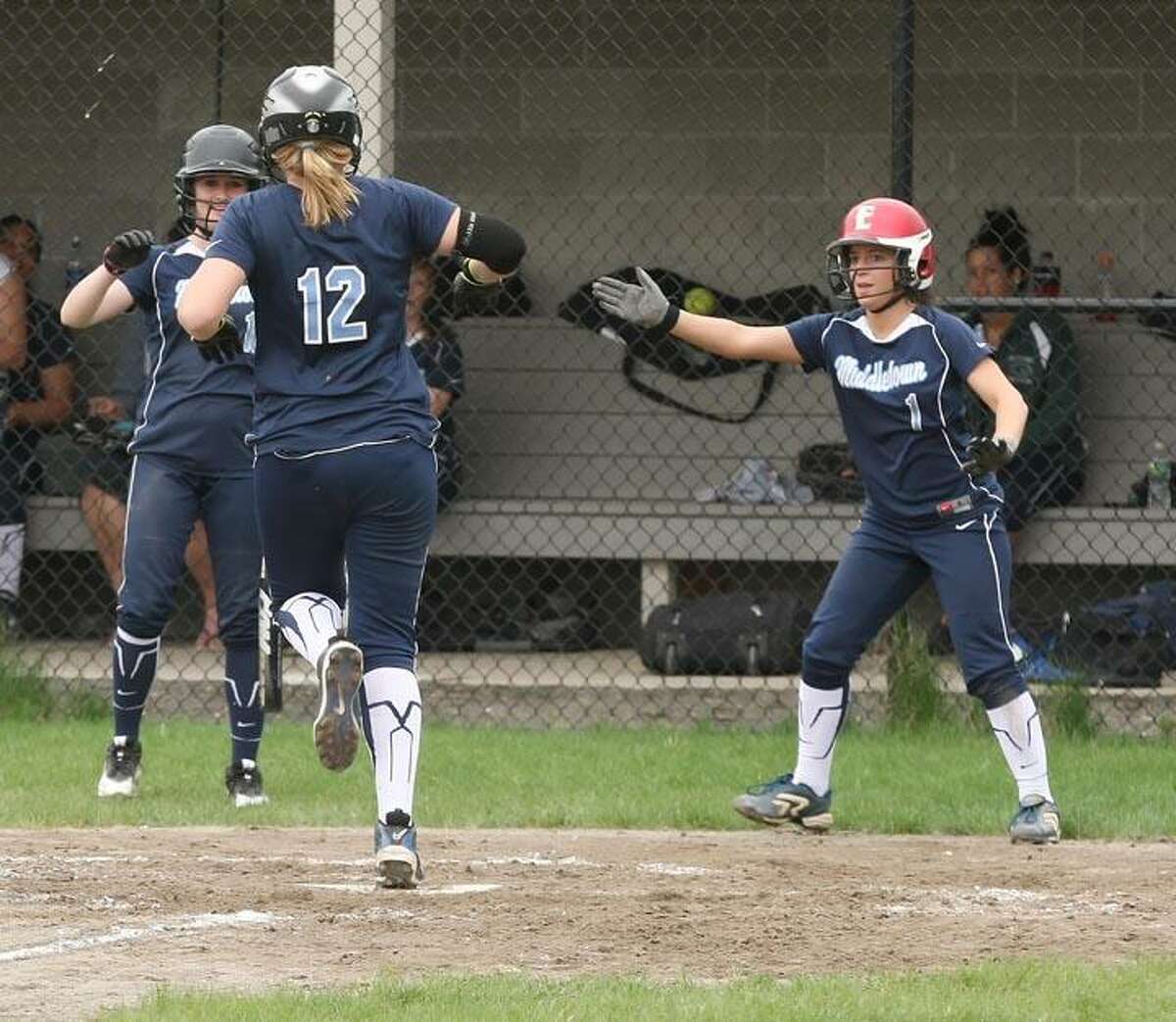 Todd Kalif/Special to The Press Middletown's Katherine Mosca and Cara Brainard welcome Ashley Tucker at the plate at the end of her home run in the second inning of Middletown's 3-0 softball win over Plainville on Wednesday.