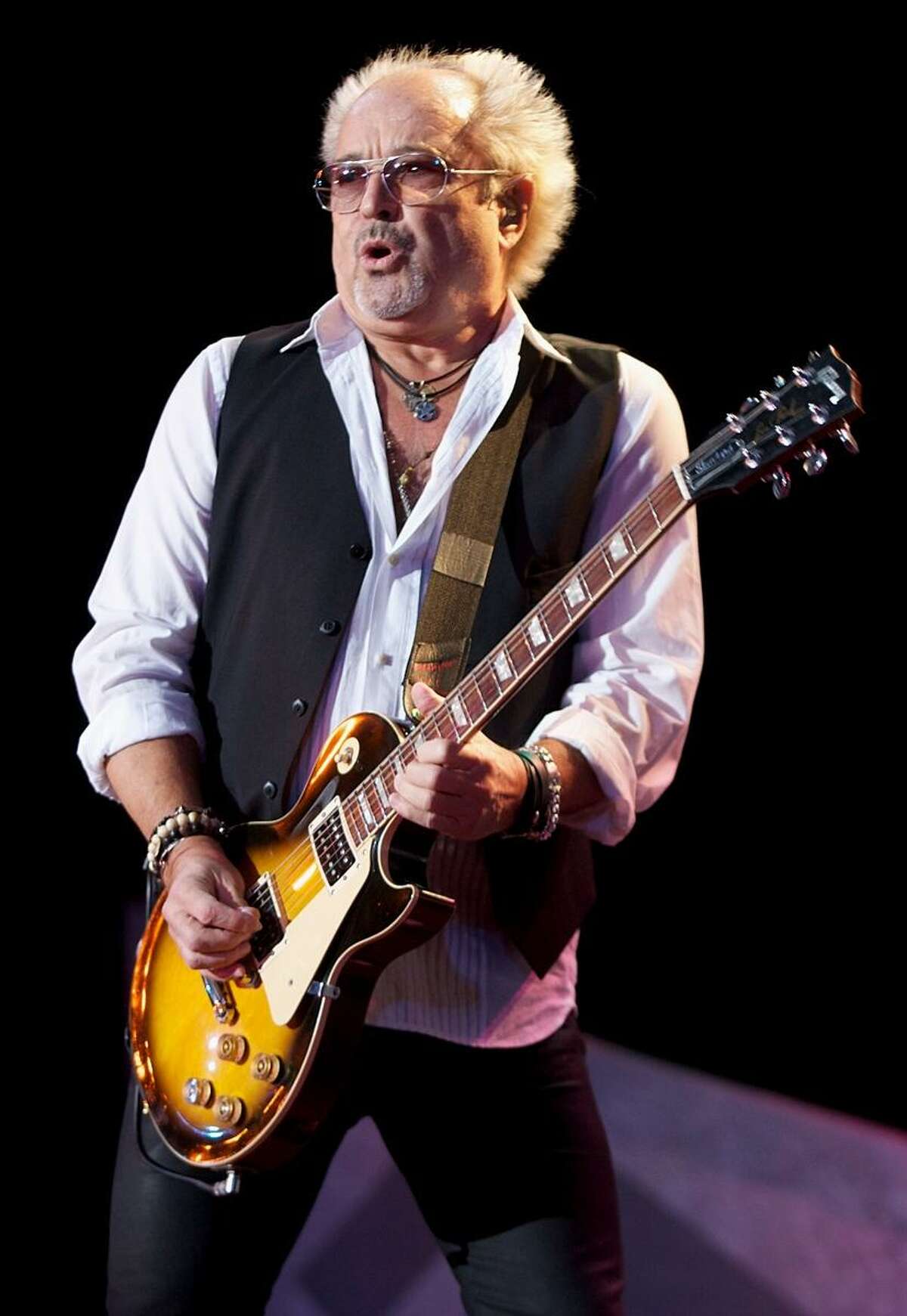 Foreigner guitarist and founding member Mick Jones is shown performing on stage during a "live" concert appearance.