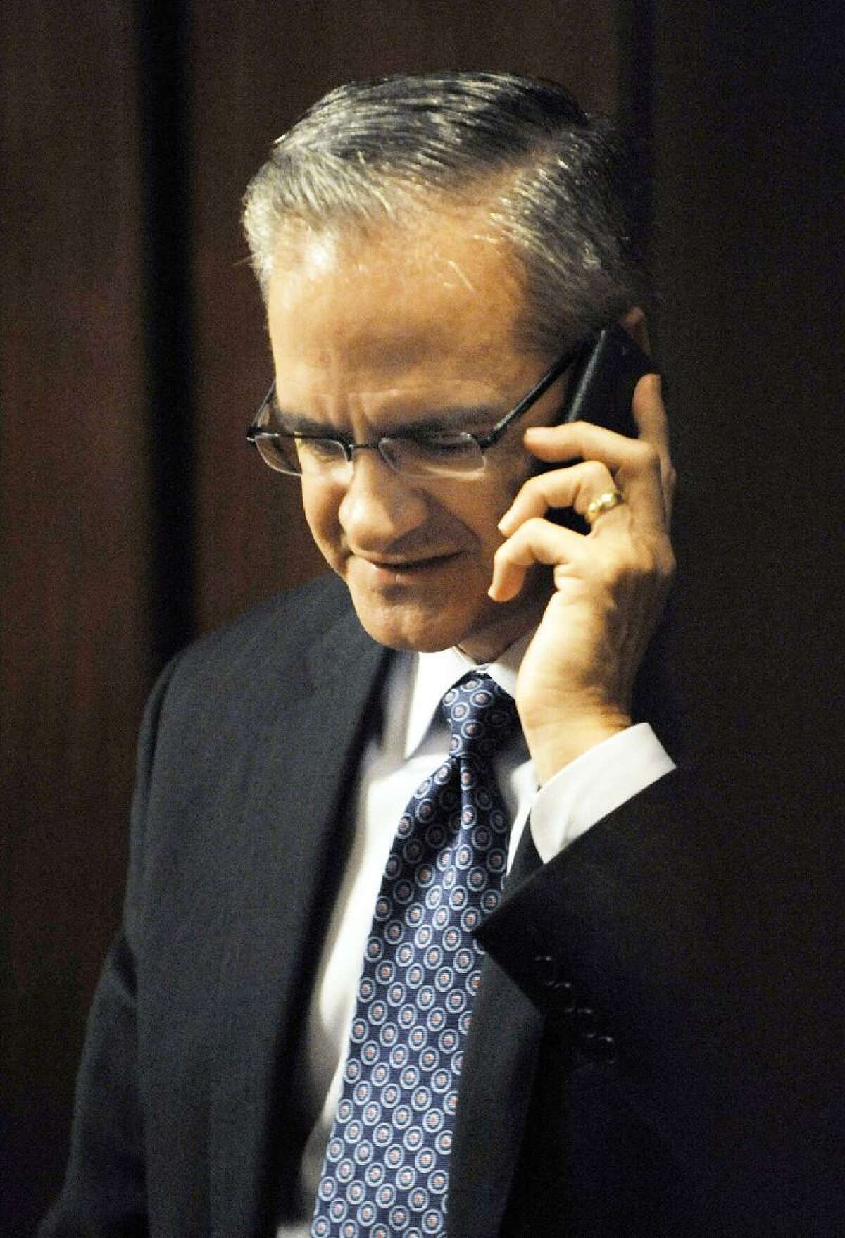 ASSOCIATED PRESS University of Connecticut athletic director Jeff Hathaway talks on his cell phone during a break from an NCAA infractions committee hearing in Indianapolis on Oct. 15, 2010. Hathaway has retired from the job after an unflattering review of his job performance.