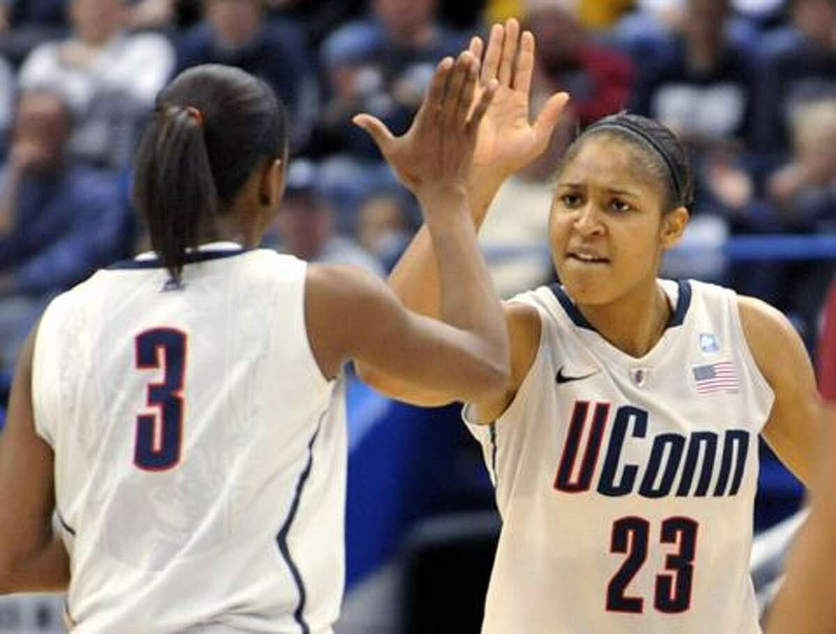 Connecticut forward Maya Moore (23) reacts with teammate Tiffany Hayes (3) in the first half of a college basketball game against Florida State in Hartford, Conn., Tuesday, Dec. 21, 2010. Heading into the game, Connecticut needed one win to set the NCAA record for consecutive wins by a basketball team. (AP Photo/Jessica Hill)