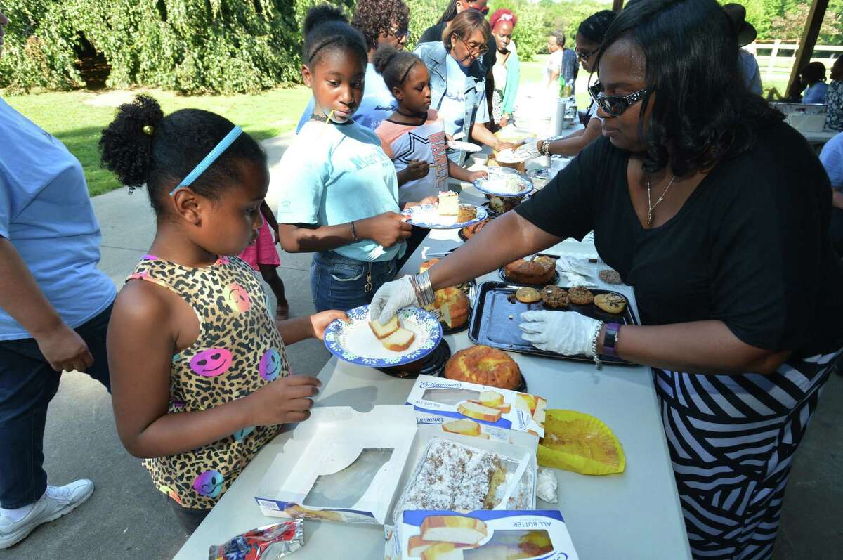 Laverne Johnson passes out the cake and cookies to Amaya Weldon during the Calvary Baptist Church picnic at Cranbury Park on Sunday Aug. 13 in Norwalk. Parishioners enjoyed food, games, music and more during the annual event for the Norwalk church.
