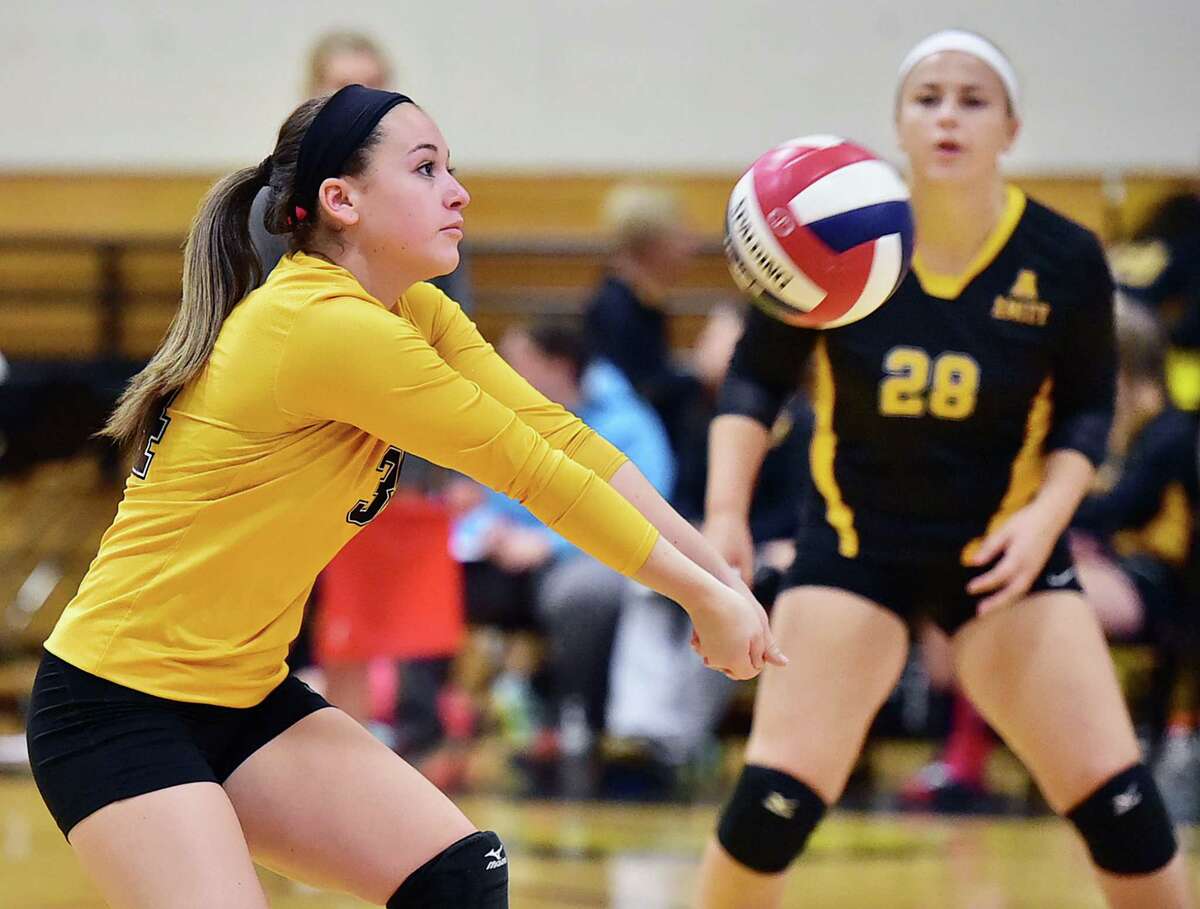 Amity's Brooke Matyasovky (28) keeps her eye on the ball as her teammate Cassidy Kirby bumps a shot up to the net against Daniel Hand of Madison, Wednesday, October 14, 2015, at the Amity High School gymnasium in Woodbridge. (Catherine Avalone/New Haven Register)