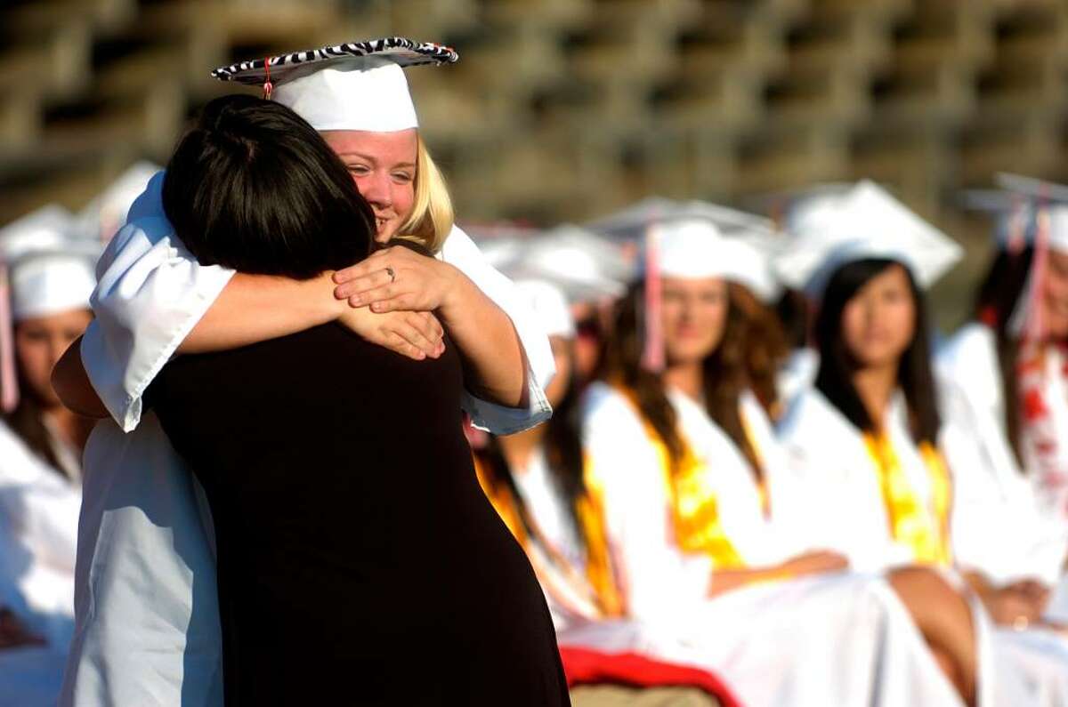 Samantha Tabone gets a hug after being awarded a scholarship during the Derby High School graduation ceremony Friday, June 18, 2010.