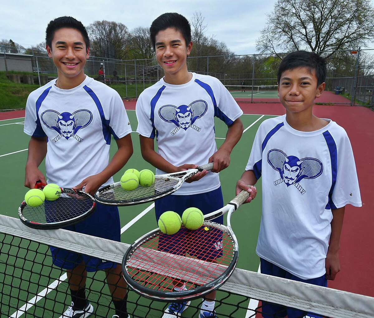 The Delgado brothers, John, a senior, James, a sophomore and Joseph, a freshman, at practice, Friday, April 29, 2016, at the courts at Painter Park in West Haven are the top seeded single players, respectively, at West Haven High School's. The Delgado brothers emigrated to the United States ten years ago from the Phillipines. (Catherine Avalone/New Haven Register)