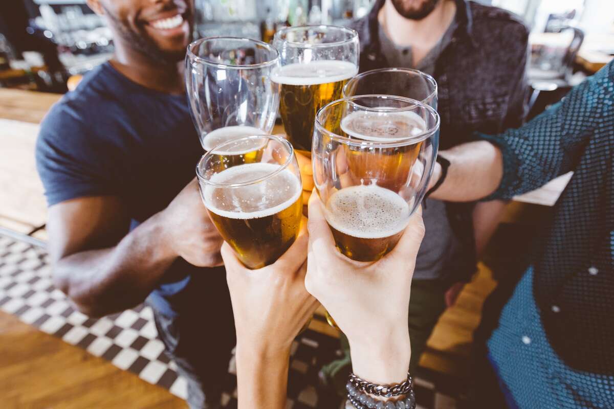 A group of friends drink beer at a pub.