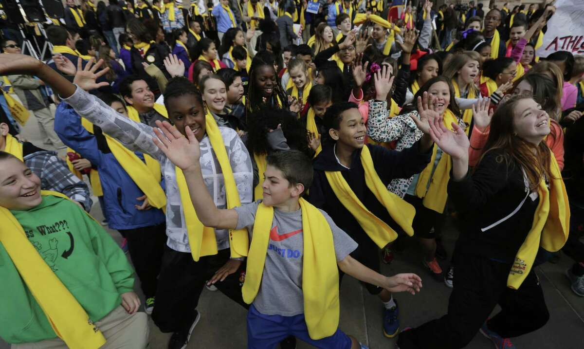 Students dance in front of the Texas Capitol during a school choice rally in 2015. School choice supporters called for expanding voucher programs and charter schools statewide. Charter schools in particular fill a niche ISDs don’t.
