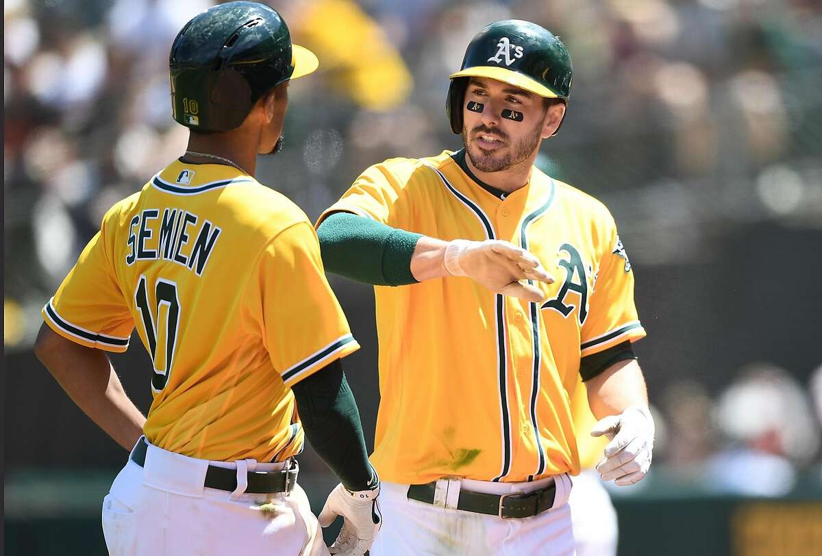 OAKLAND, CA - AUGUST 13: Matt Joyce #23 and Marcus Semien #10 of the Oakland Athletics celebrates after Joyces scored on a sacrifice fly ball from Semien against the Baltimore Orioles in the bottom of the fifth inning at Oakland Alameda Coliseum on August 13, 2017 in Oakland, California. (Photo by Thearon W. Henderson/Getty Images)