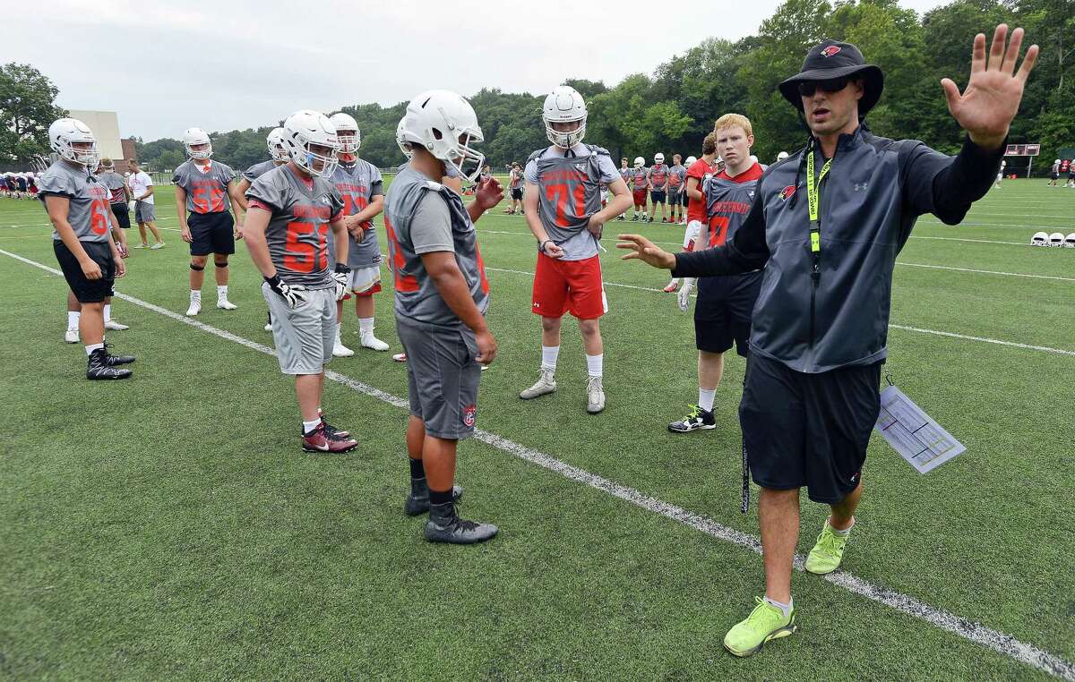 Greenwich Coach John Marinelli reviews plays with his team during the first day of fall football practice on Friday, August 18, 2017 at Greenwich High School for the 2017 FCIAC season.