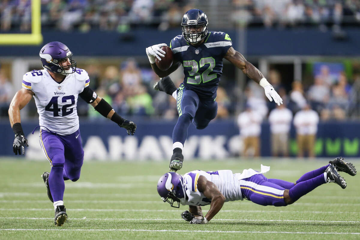 Seahawks running back Chris Carson leaps over Vikings corner back Jabari Price in the first half of a preseason game at CenturyLink Field on Friday, Aug. 18, 2017.