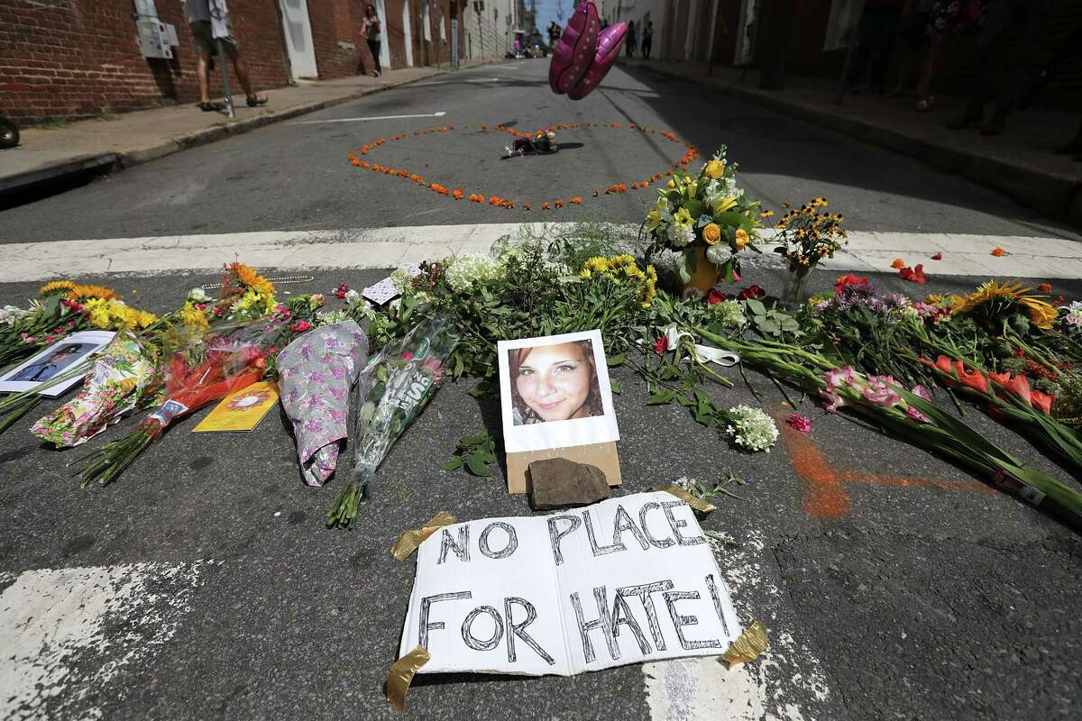 Flowers surround a photo of 32-year-old Heather Heyer, who was killed when a car plowed into a crowd of people protesting against the white supremacist Unite the Right rally in Charlottesville, Va.