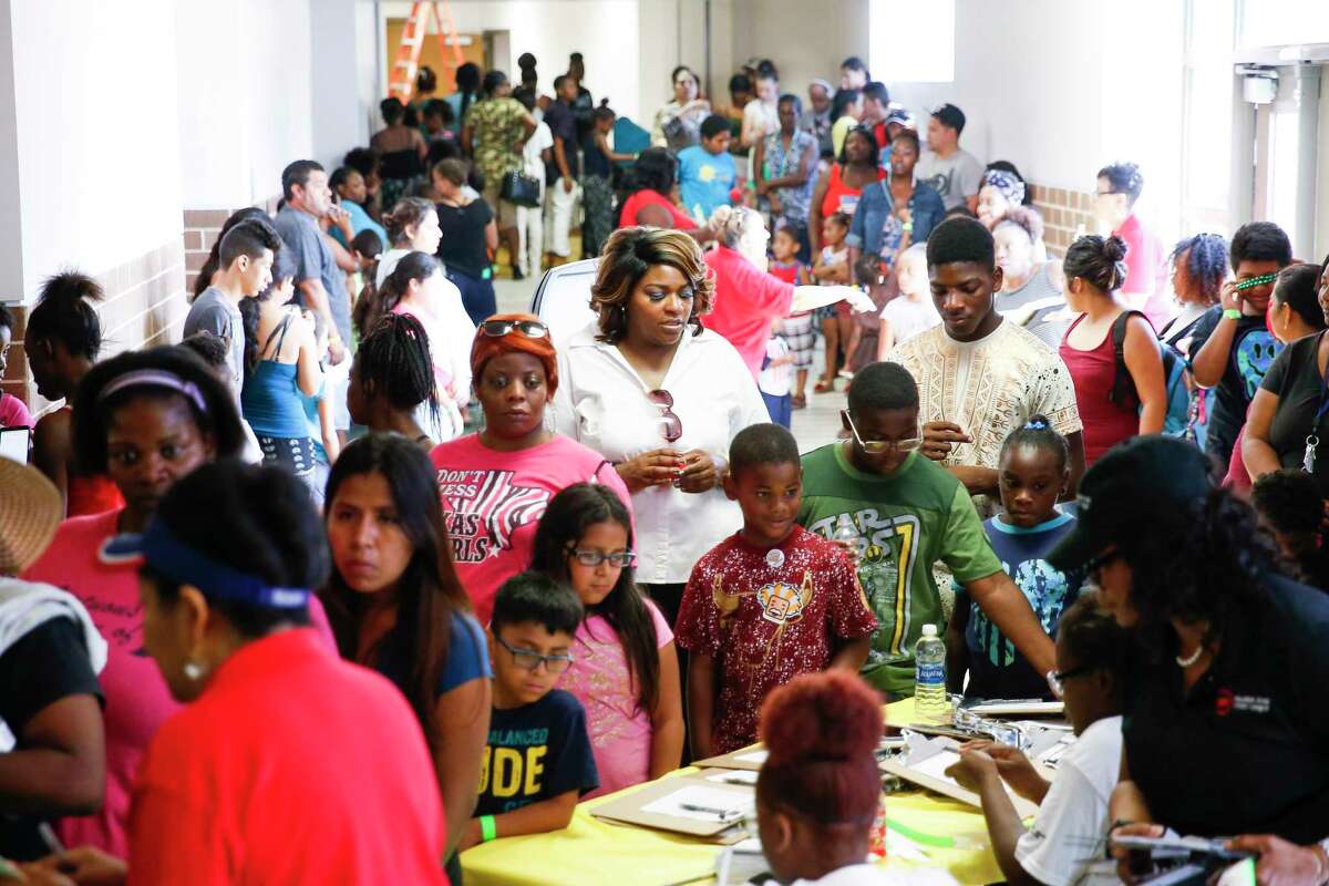 Students and parents wait in line to register for free backpacks, uniforms and school supplies at the Southside Takeover event at Worthing High School for schools participating in HISD's ACHIEVE 180 initiative Saturday, Aug. 19, 2017 in Houston.