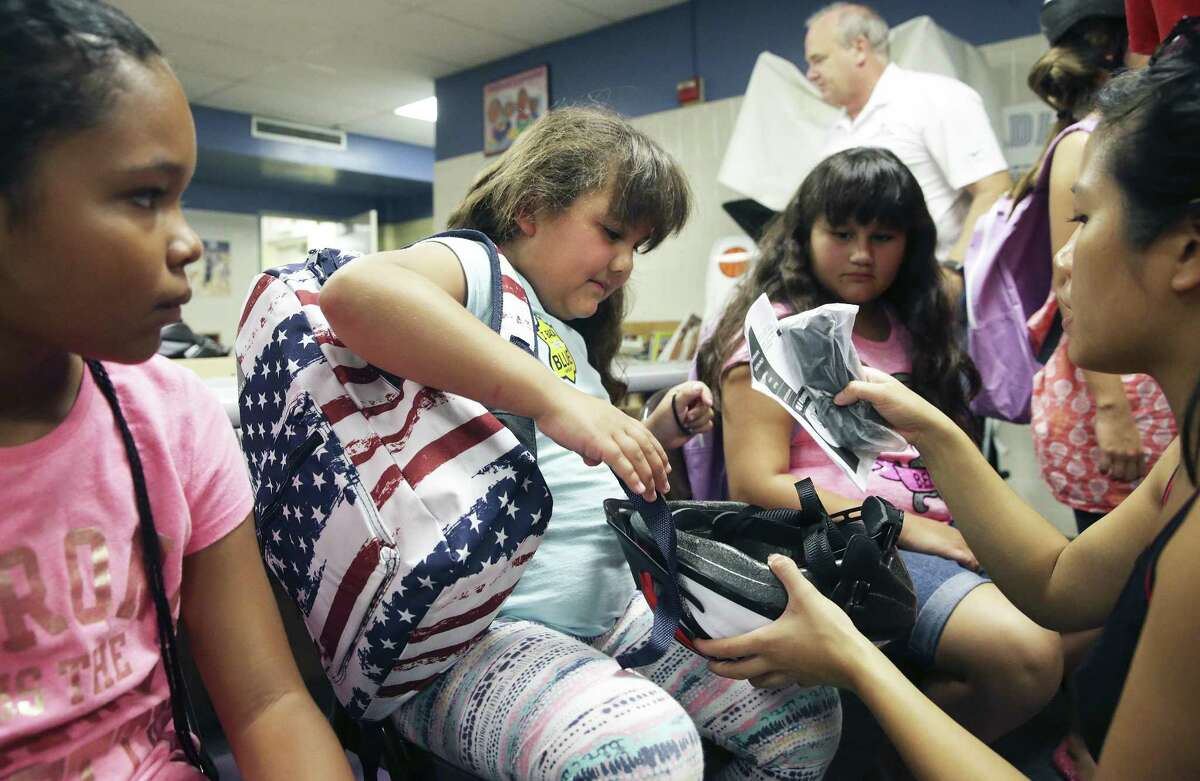 Second grader Savannah Faircloth shoulders her new gear as kids get backpacks and bicycle helmets as well school supplies and vaccinations at the Garza Community Center back to school fair as on August 19, 2017.