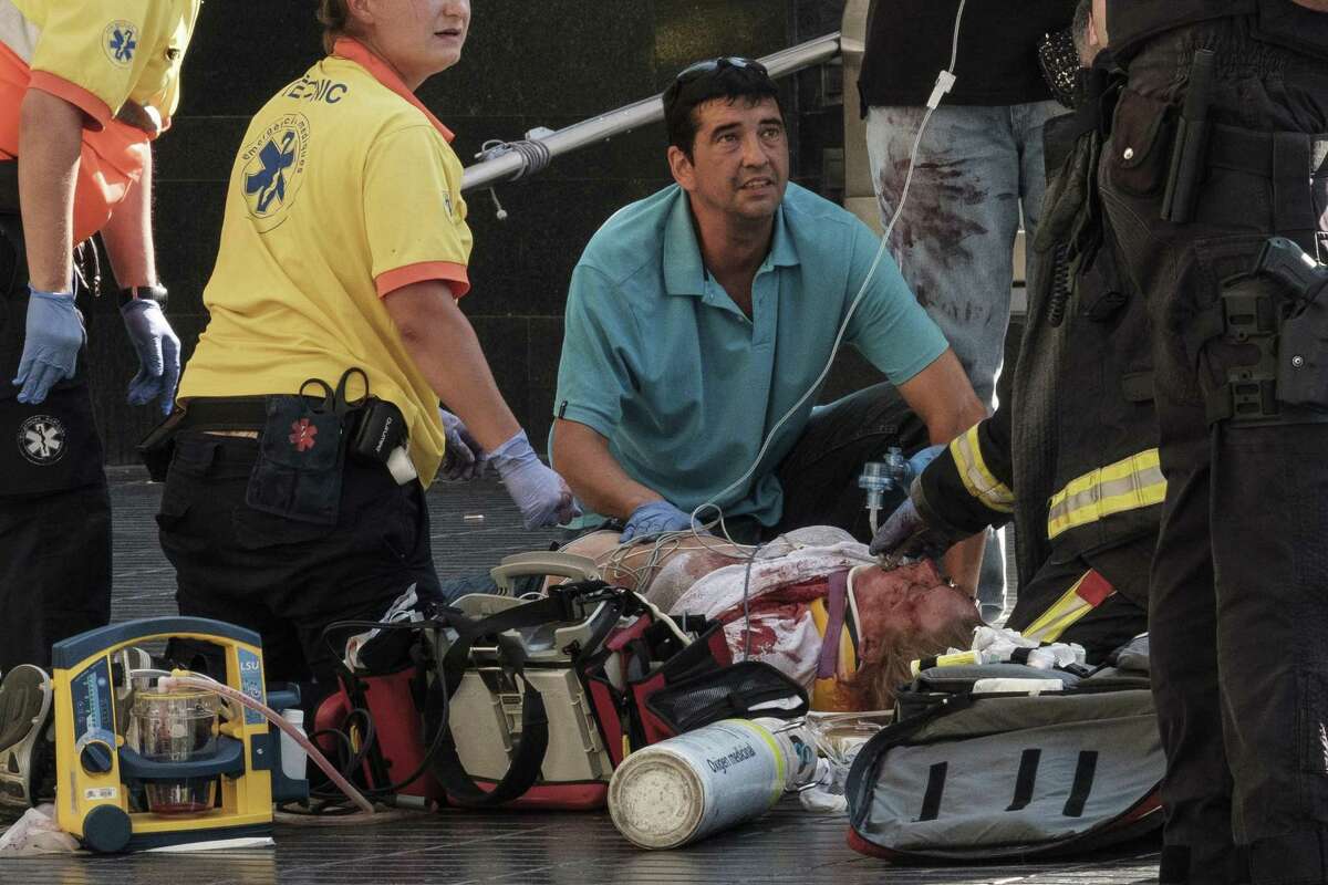 Paramedics tend to one of the many pedestrians struck by a van driving through crowds on Las Ramblas, Barcelona?’s most famous street, killing at least 12, on Aug. 17, 2017. At least 80 people were injured in what Spanish authorities described as a terrorist attack; two men have been arrested and the Islamic State group has already claimed responsibility. (Sergi Alcazar/El Nacional via The New York Times) -- NO SALES; FOR EDITORIAL USE ONLY WITH STORY SLUGGED BARCELONA-CRASH FOR AUG. 18, 2017. ALL OTHER USE PROHIBITED. ?—