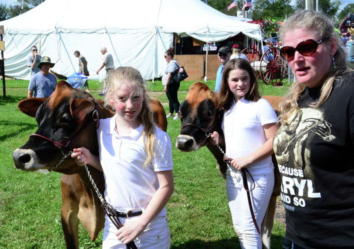 Becky Wheeler, 9, left, from Roxbury, Rebecka Klug, 9, from Torrington and Kris Wheeler from Roxbury wait for their turn in front of the judges for Two Best Female cows during the Bridgewater Country Fair on Saturday, August 19, 2017.