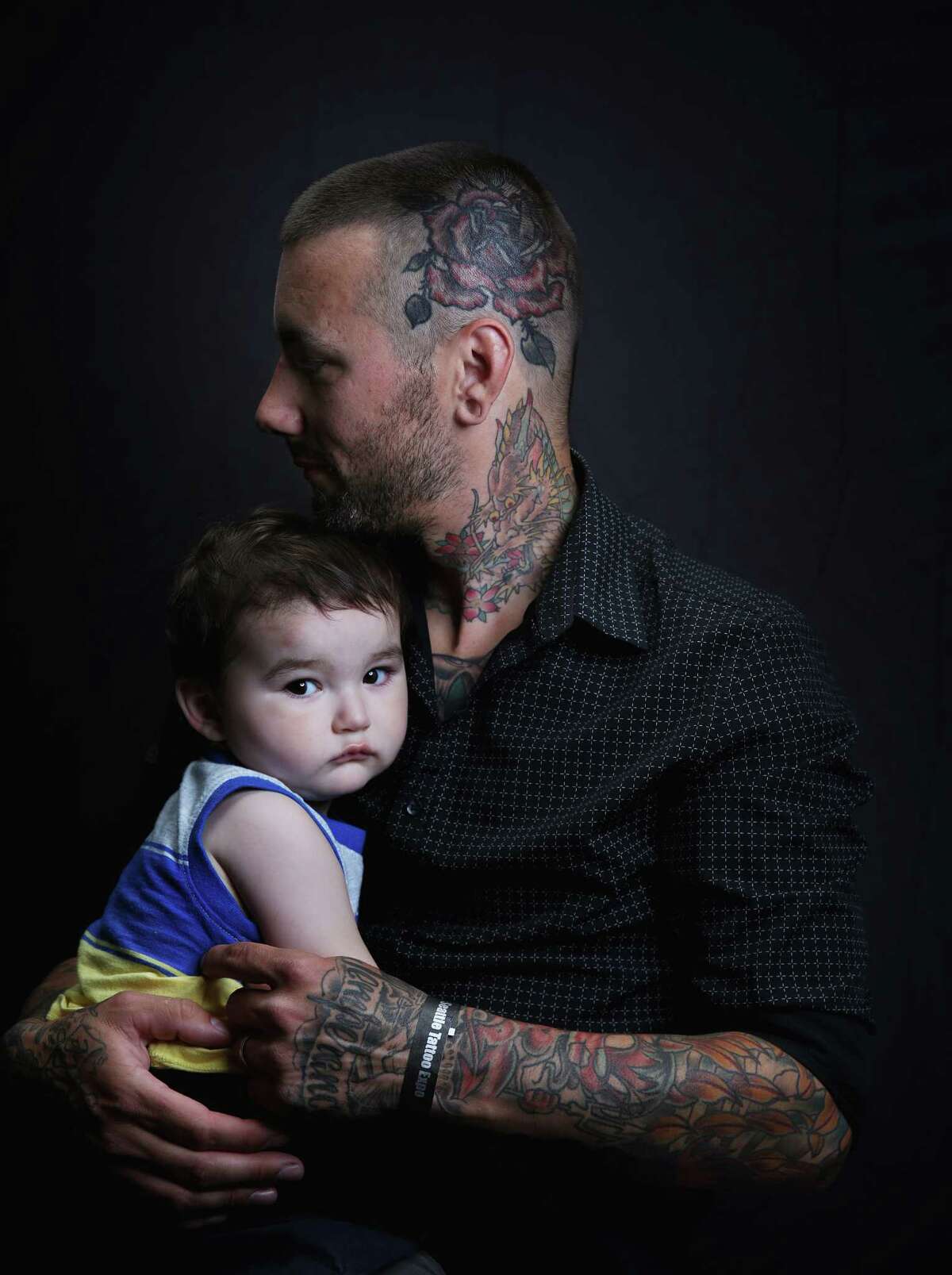 Curtis Stairs, a tattoo artist at Blue Geisha, and his one-year-old son Elijah pose for a portrait at the annual Seattle Tattoo Expo, Aug. 19, 2017 at Fisher Pavilion.