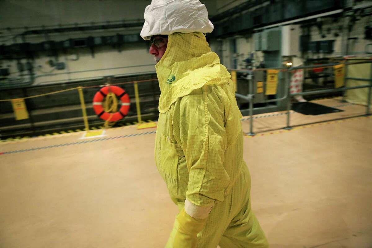 A worker clad in protective ware walks past the spent fuel pool at the South Texas Nuclear Project Electric Generating Station.