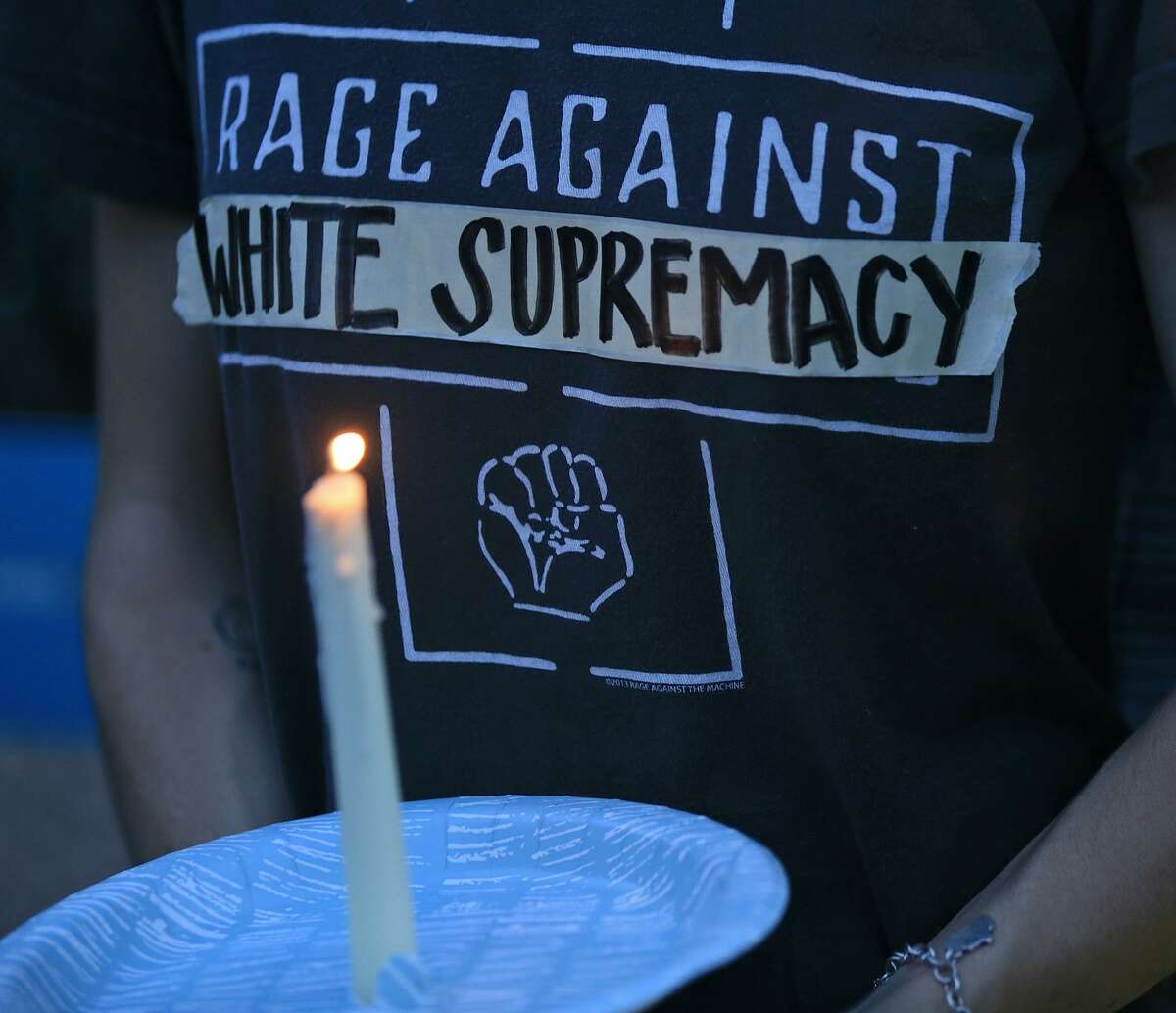 People attend a candle light vigil, Sunday Aug. 13, 2017 at Travis Park, for the victims in Charlottesville, Va.